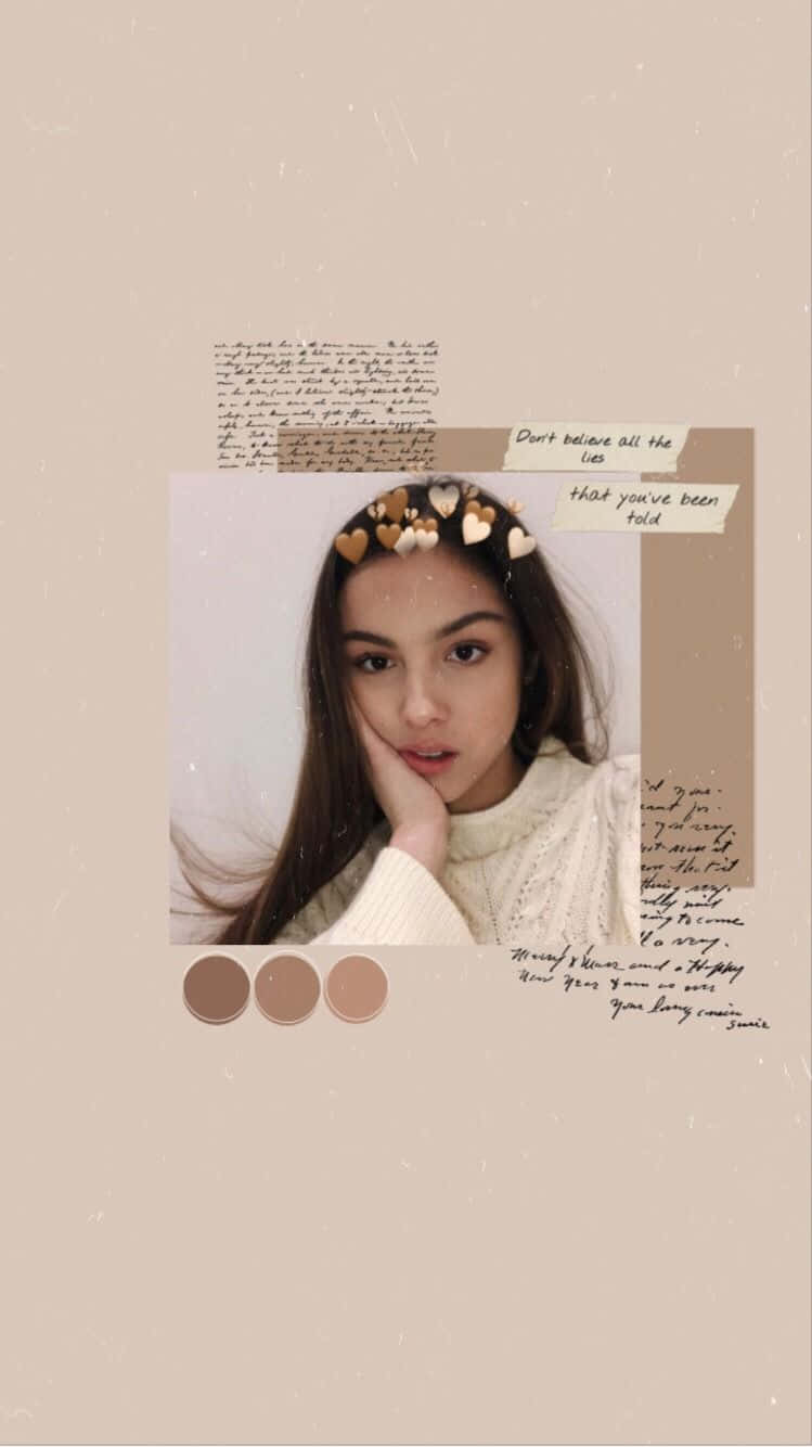 Olivia Rodrigo Aesthetic 桌布 壁紙 — 一位年輕女性戴著心形髮夾，手托下巴，背景是米色，上面有手寫筆記和色板。