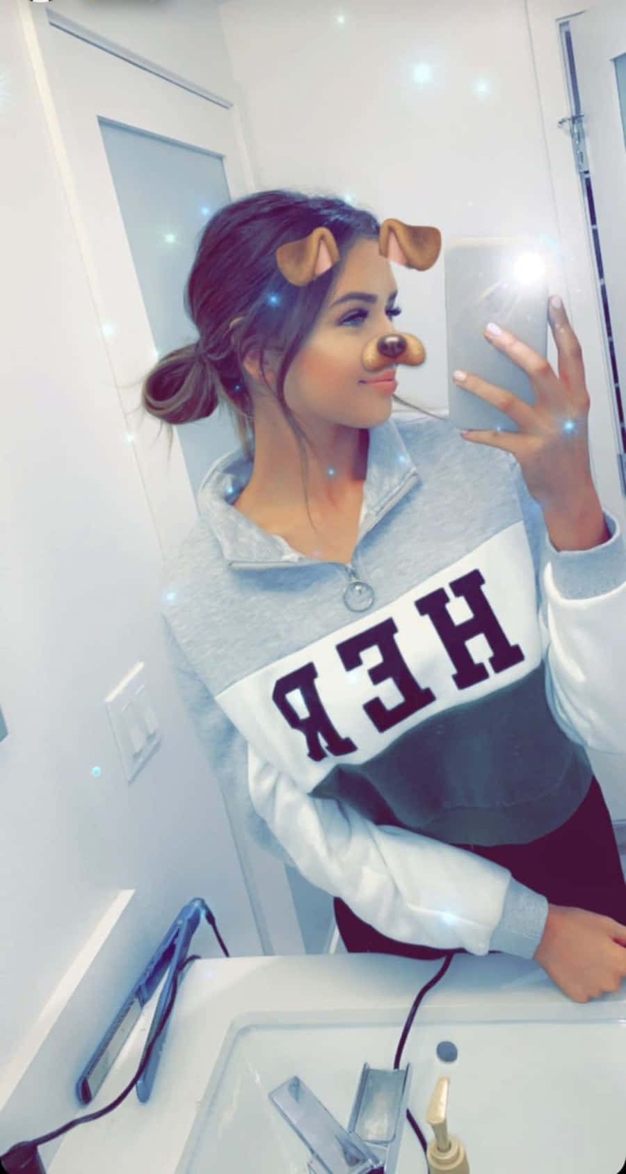 Snapchat 桌布 壁紙 — 一位年輕女性戴著狗耳朵和鼻子濾鏡，在浴室鏡子前微笑自拍。
