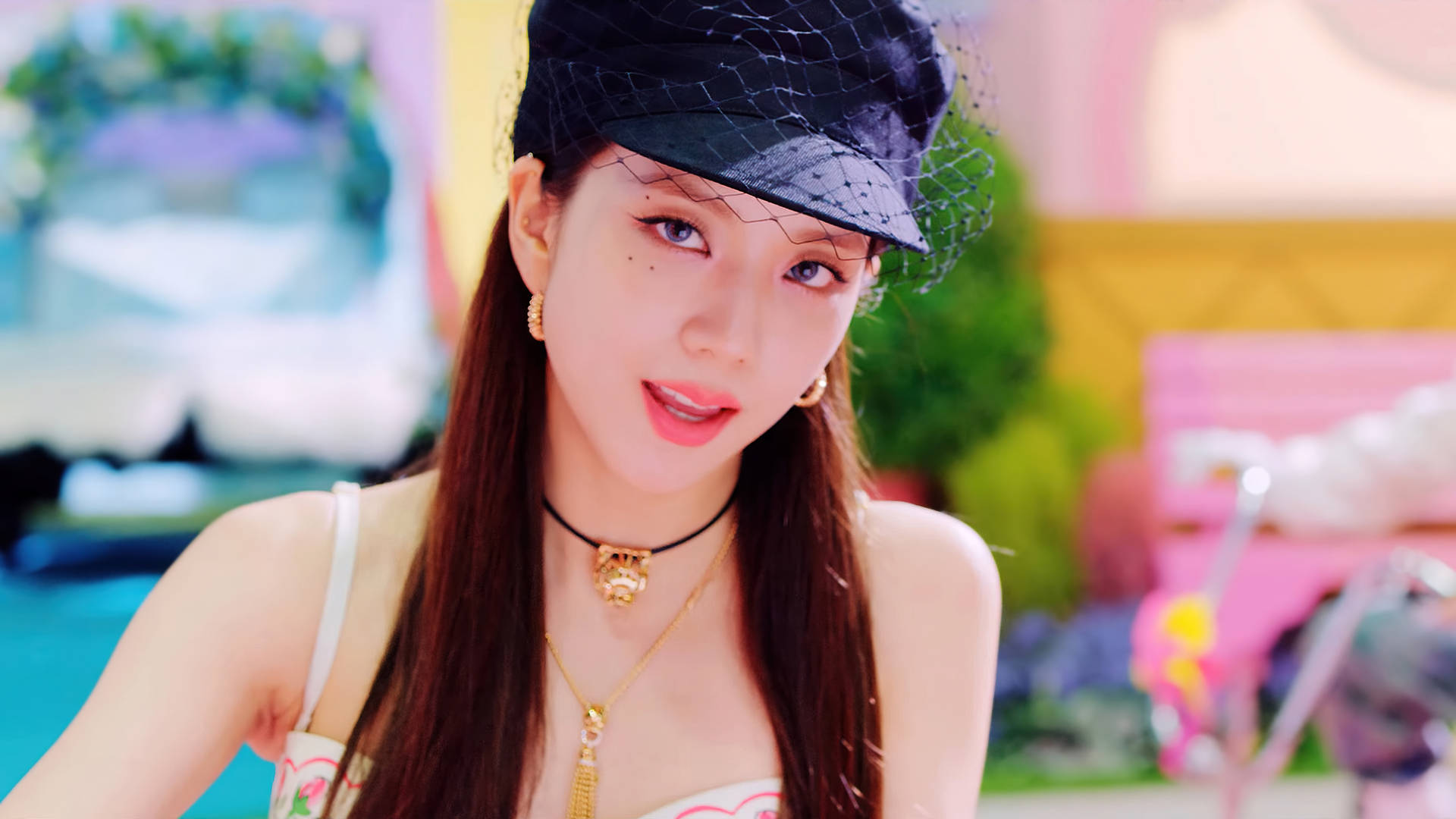 年輕女性戴著黑色帽子和金飾在戶外微笑。 — 智秀 GIF 壁紙