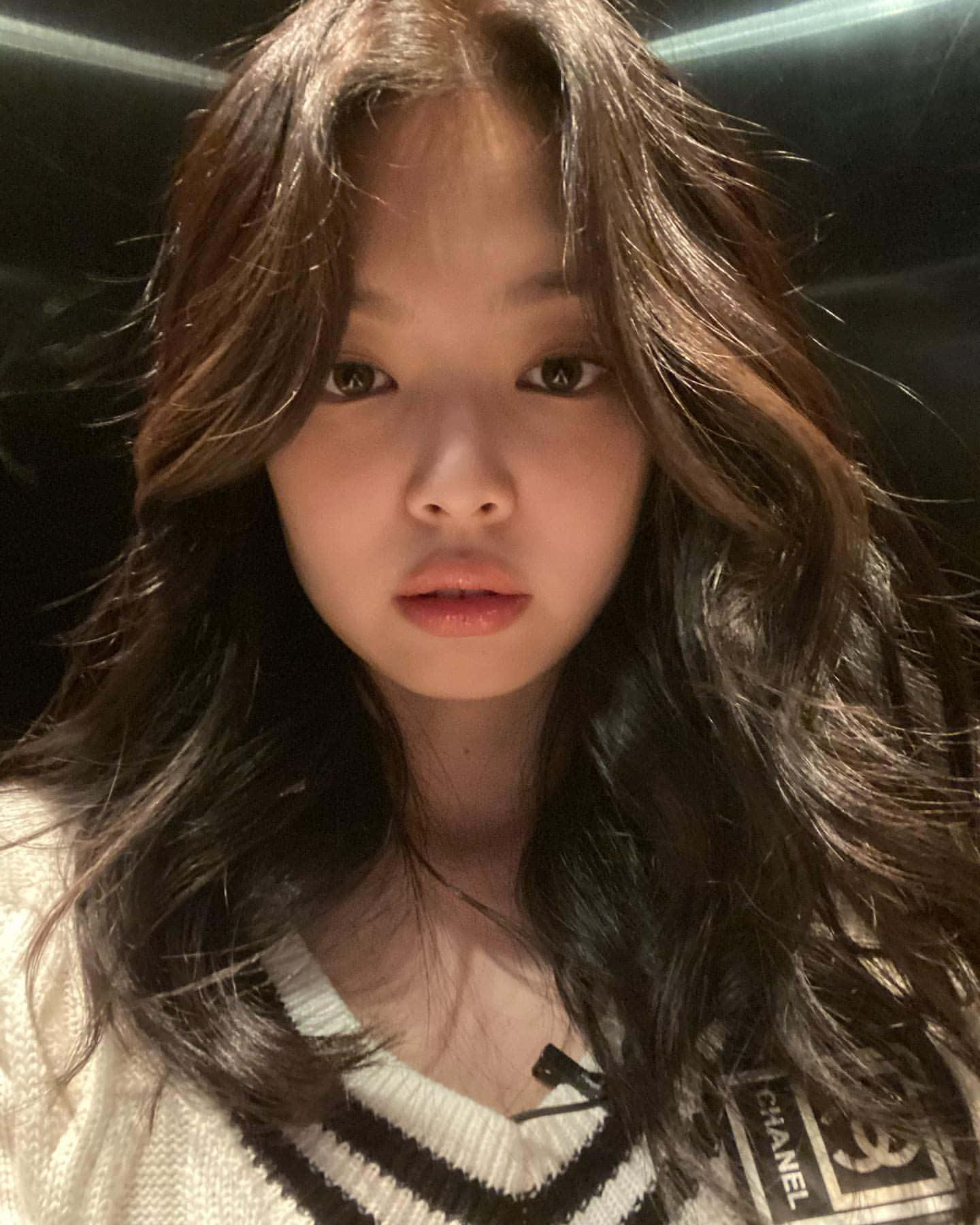 BLACKPINK 桌布 壁紙 — 一位年輕女性的特寫肖像，她擁有長長的深色波浪髮，穿著黑白條紋毛衣，背景為深色。
