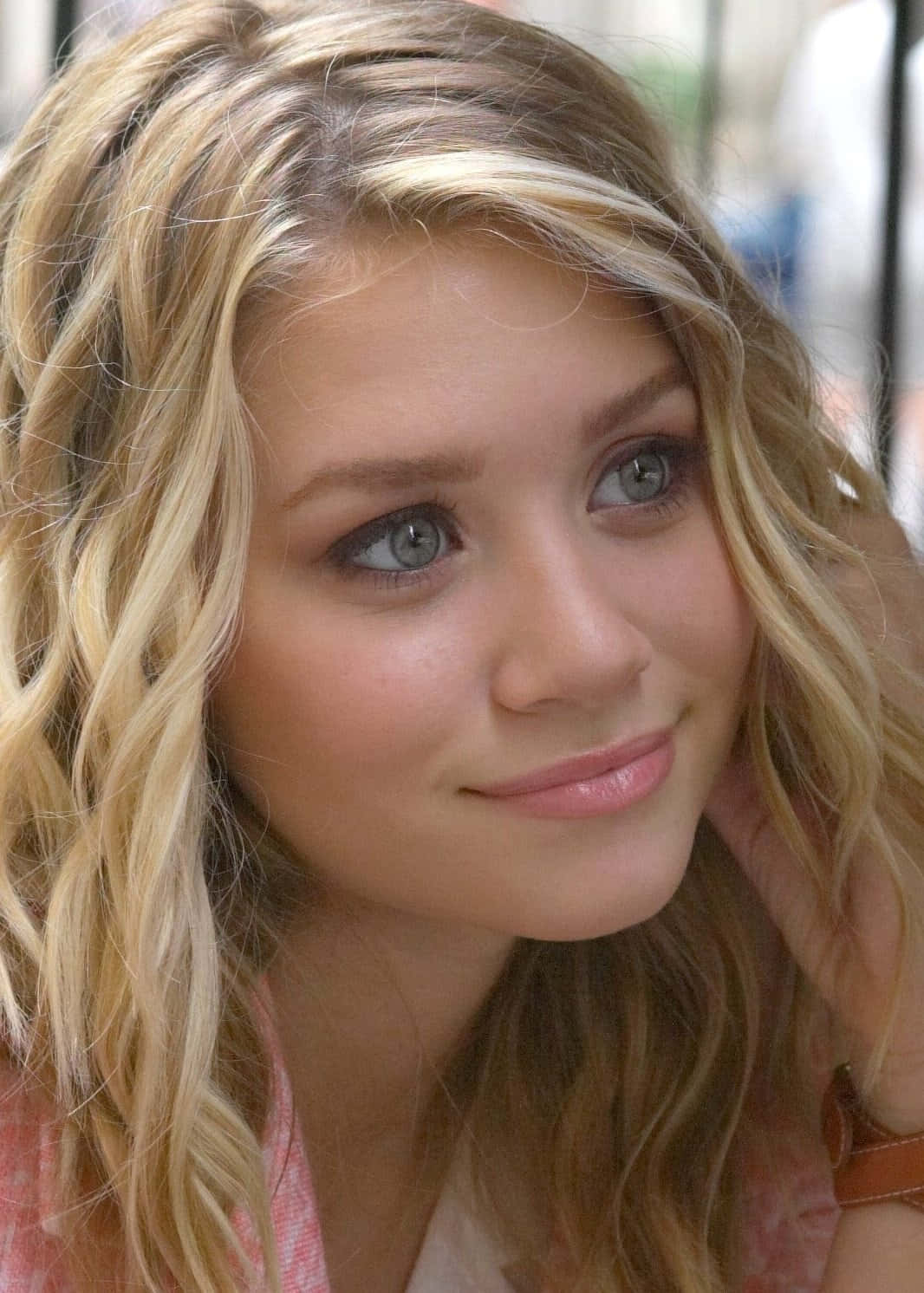 Mary Kate Olsen 桌布 壁紙 — 一位年輕女性的特寫肖像，她有波浪形金髮和藍色眼睛，對著鏡頭溫柔地微笑。