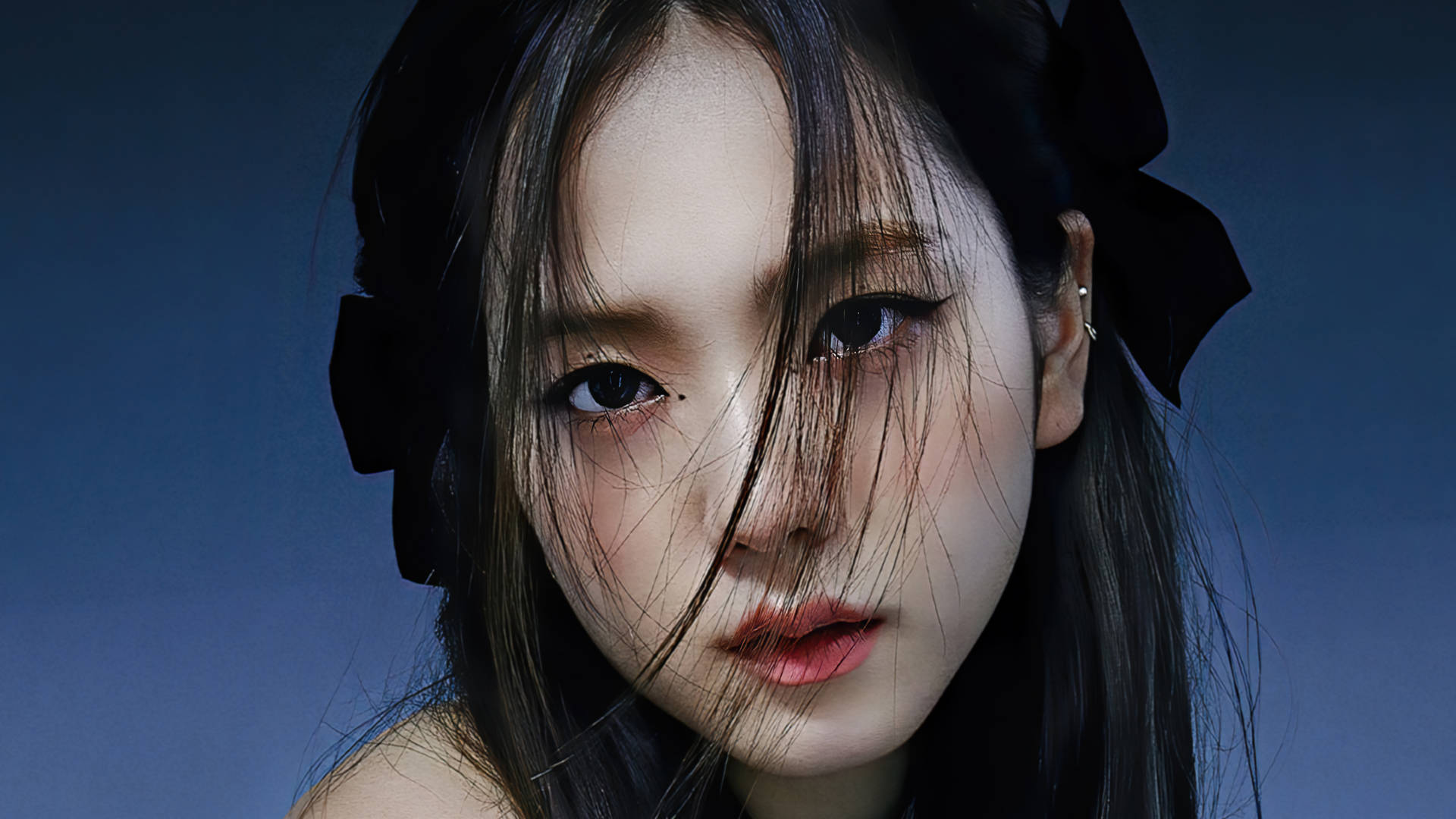 深色頭髮、戴著黑色蝴蝶結的年輕女性直視觀眾。 — 智秀 GIF 壁紙