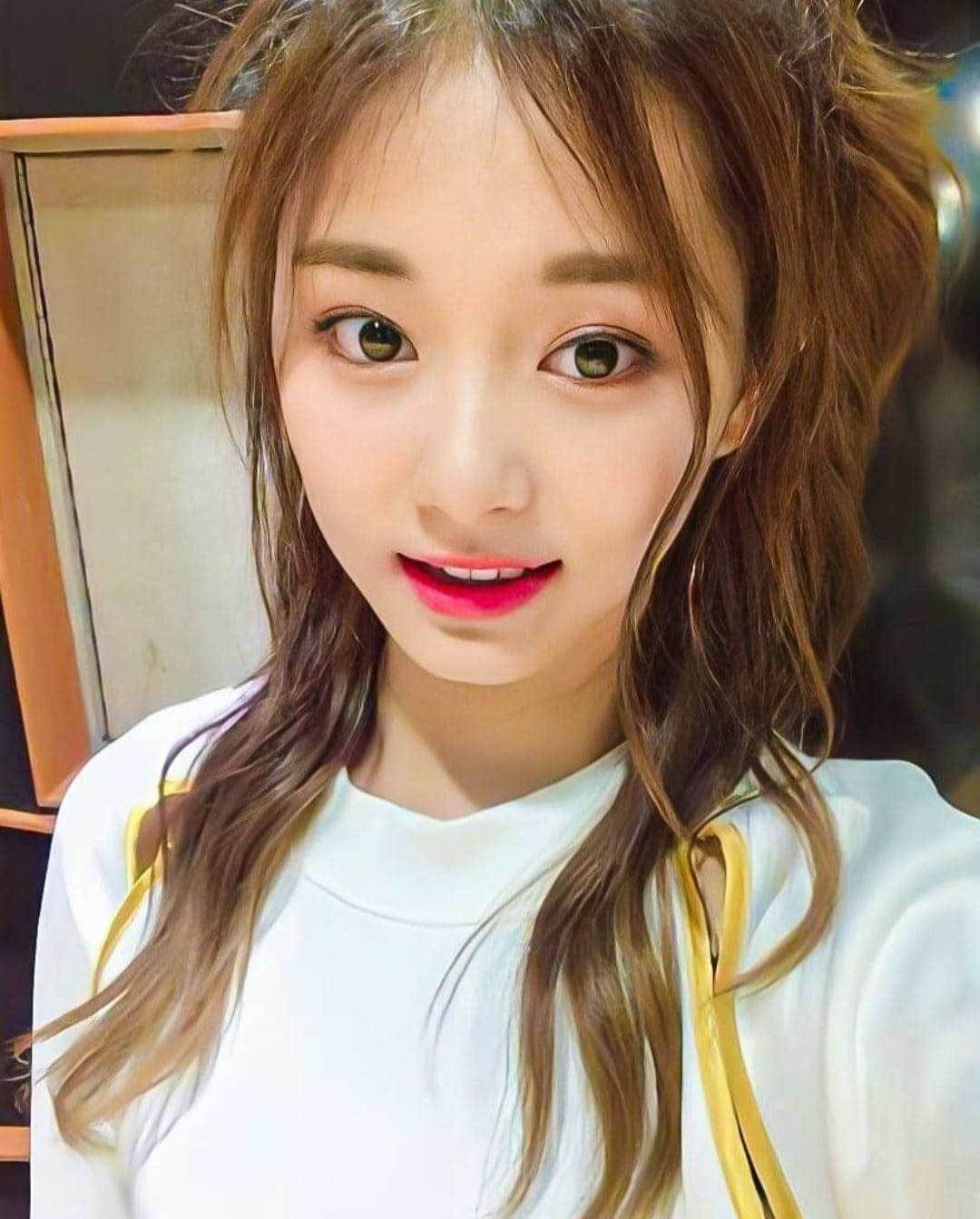 子瑜 桌布 壁紙 — 一位年輕女性的近距離自拍，她有棕色頭髮和鮮紅色嘴唇，對著鏡頭微笑。