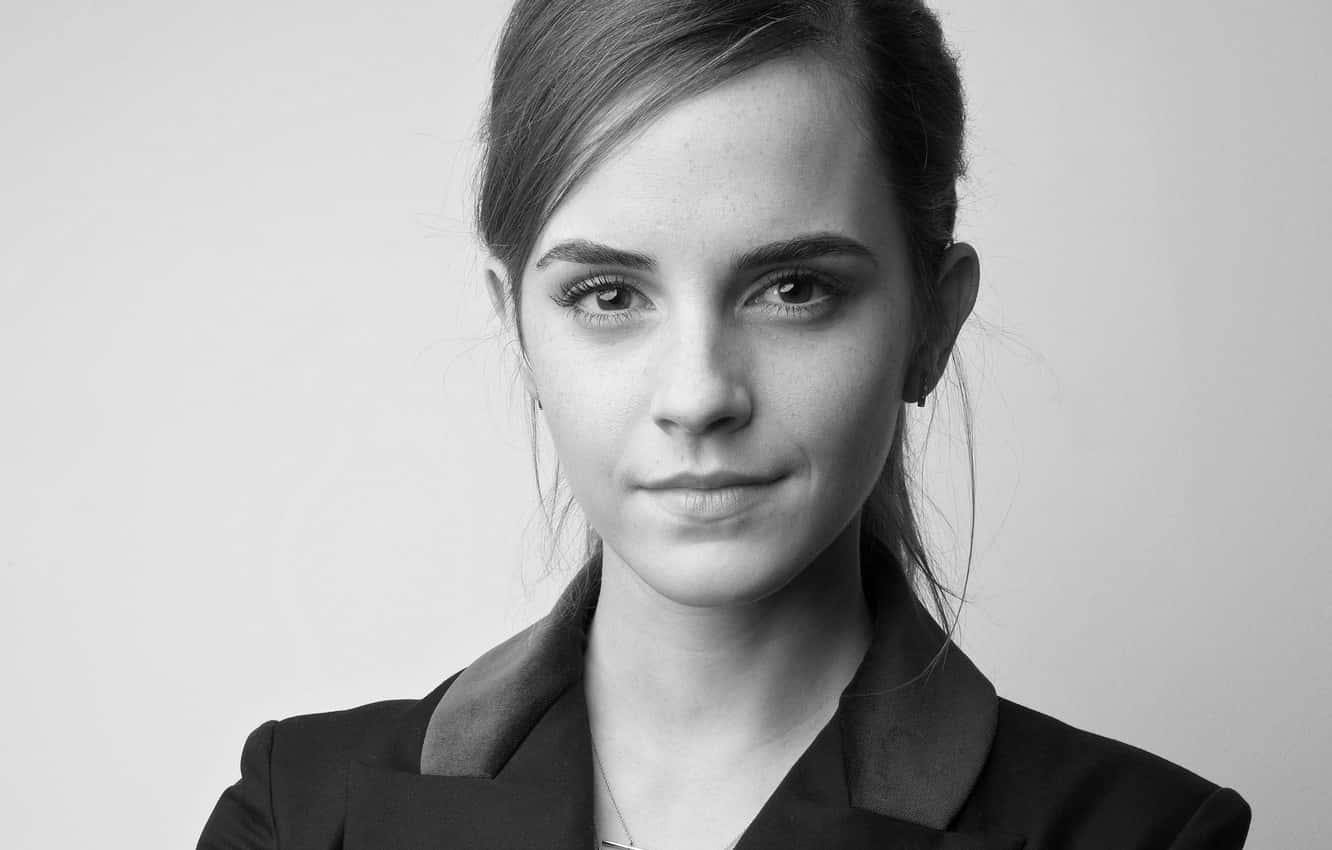 Black And White Celebrity 桌布 壁紙 — 一位年輕女性的黑白肖像，帶著微妙微笑，穿著深色西裝外套，背景樸素。
