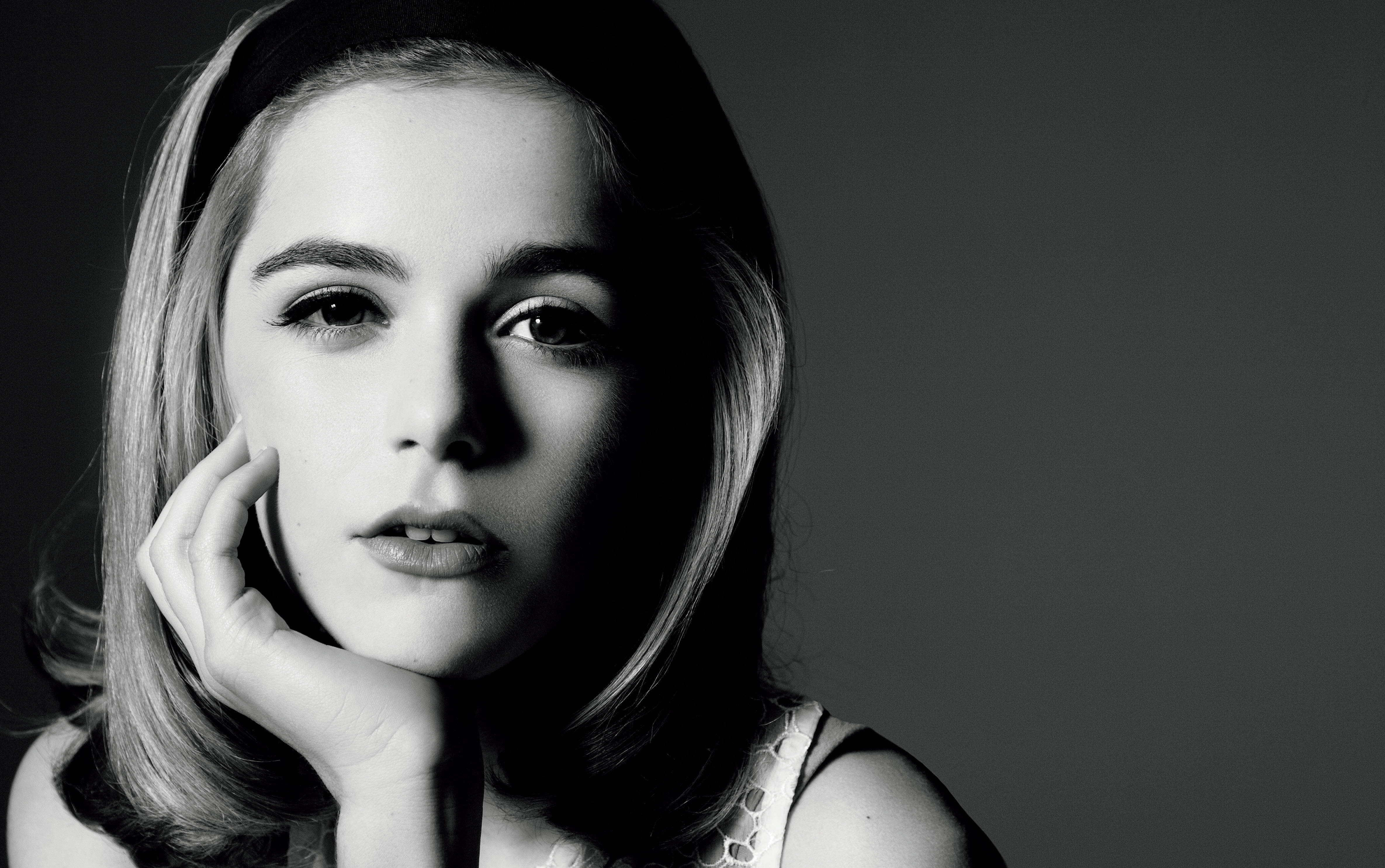 Kiernan Shipka 桌布 壁紙 — 一位年輕女性的黑白肖像，手托下巴，若有所思地凝視鏡頭。