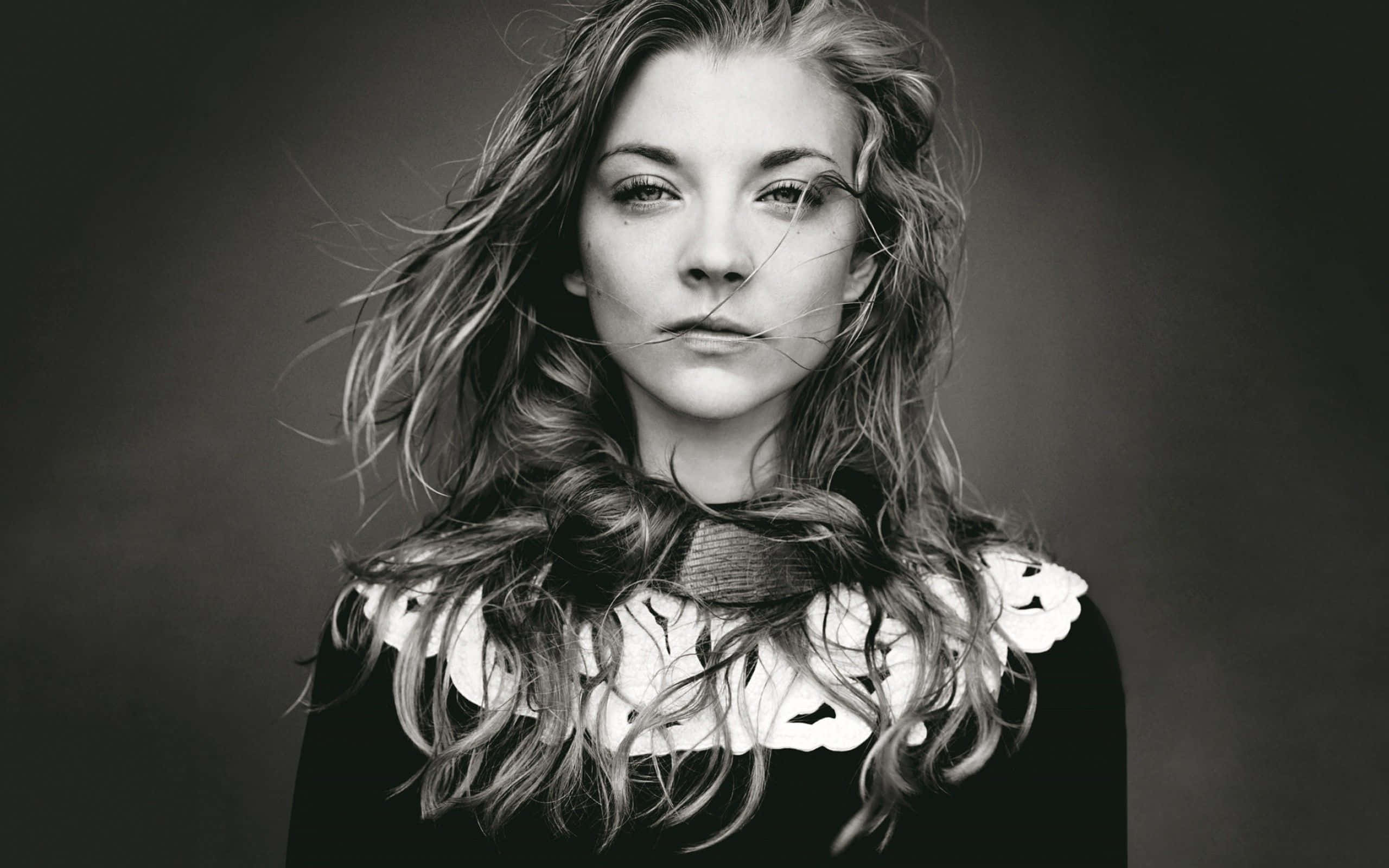 natalie dormer 桌布 壁紙 — 一位年輕女性的黑白肖像，頭髮被風吹亂，穿著蕾絲領，直視鏡頭。