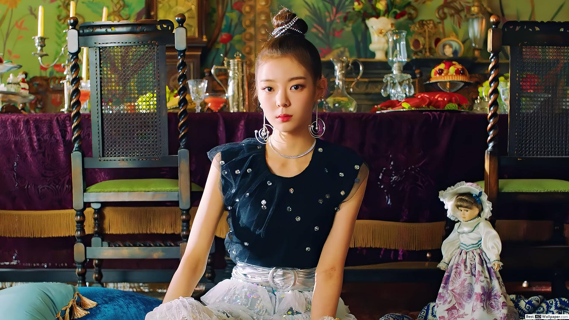 ITZY 桌布 壁紙 — 一位年輕女性身穿深色裝飾上衣和白色裙子，端莊地坐在裝飾華麗的復古房間中，旁邊有精緻家具和一個娃娃。