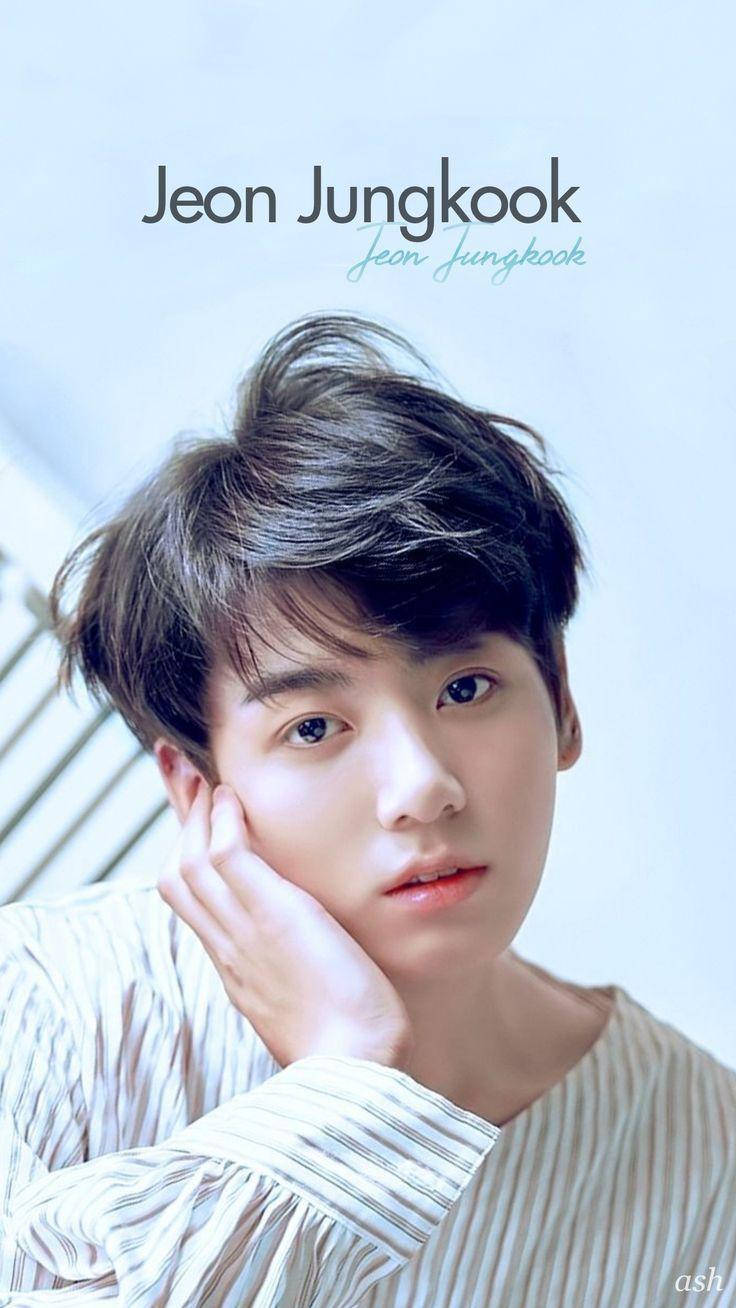 Jungkook Aesthetic 桌布 壁紙 — 一位年輕男子，一頭凌亂的黑髮，在柔和的藍色背景前用手托著下巴。
