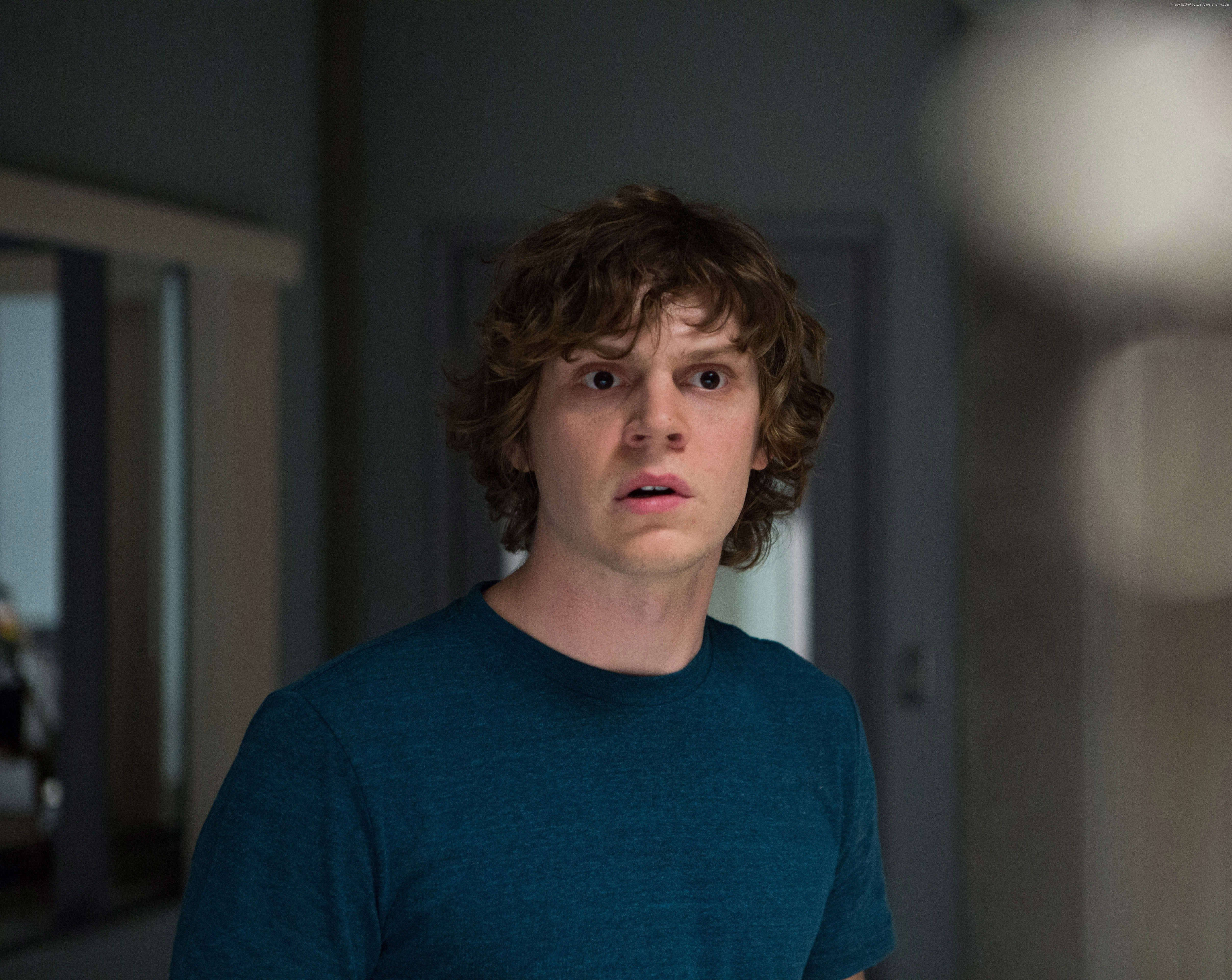 Tate Langdon 桌布 壁紙 — 一位年輕男子，棕色捲髮，大眼睛，穿著青綠色T恤，在室內震驚地凝視著。