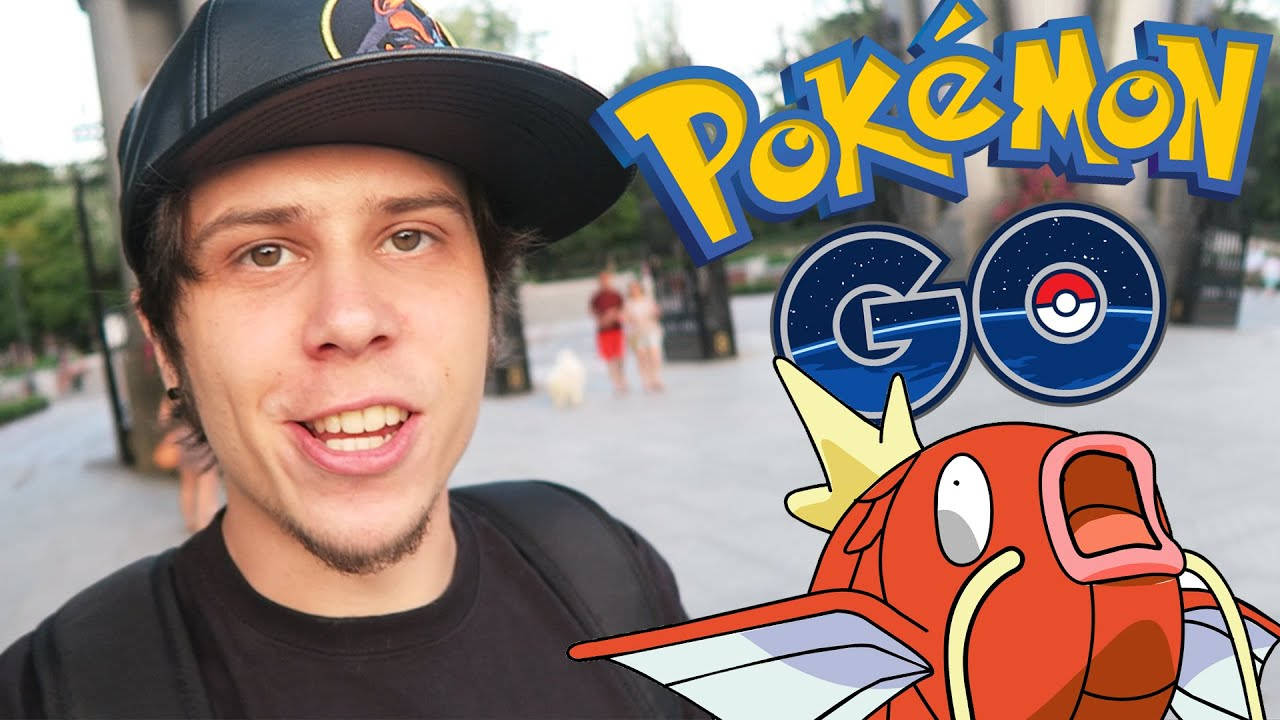 寶可夢 桌布 壁紙 — 一位年輕男子在戶外廣場上，在卡通鯉魚王和 Pokémon GO 標誌旁邊對著鏡頭微笑。