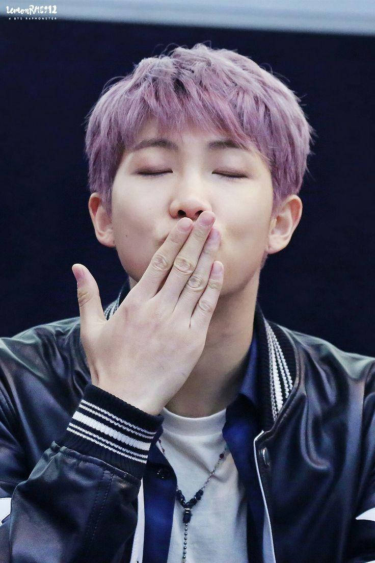 Namjoon 桌布 壁紙 — 一位年輕男子擁有鮮豔的紫色頭髮，閉著眼睛，輕輕用手遮住嘴巴，身穿黑色 bomber 外套。