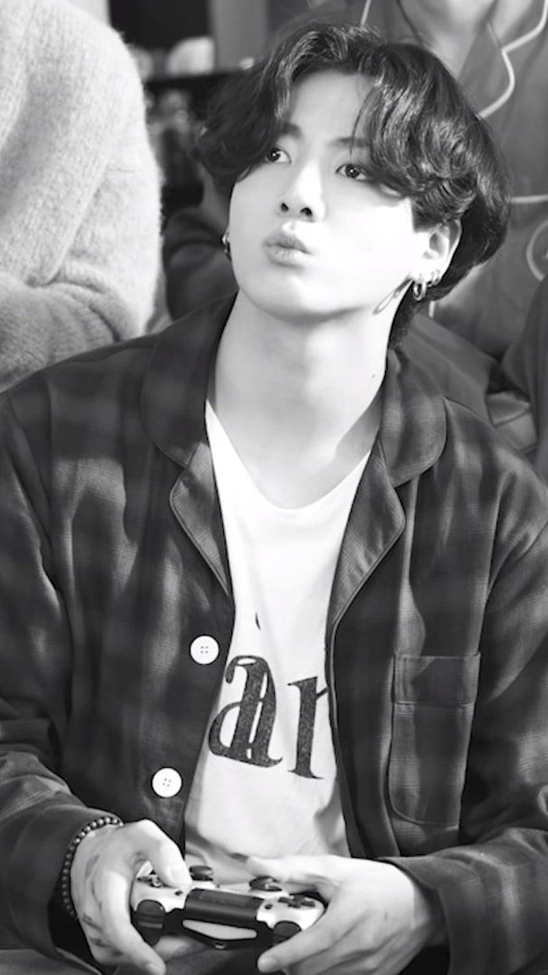 Bts Black 桌布 壁紙 — 一位年輕男子梳著時尚髮型，在黑白照片中手持遊戲控制器向上看。