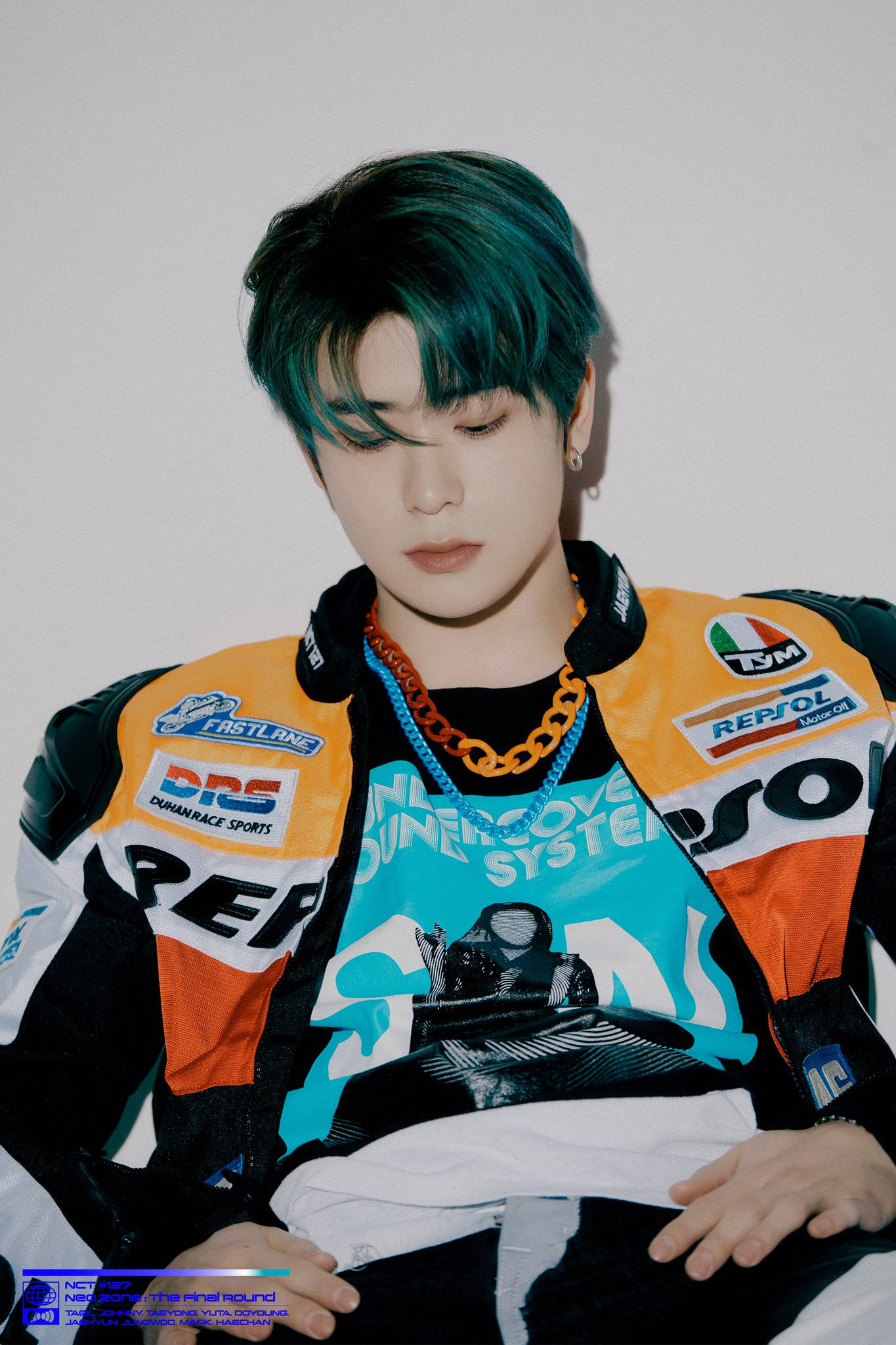 Nct 桌布 壁紙 — 一位年輕男子留著藍綠色頭髮，穿著色彩繽紛的賽車夾克，站在純白牆壁前。