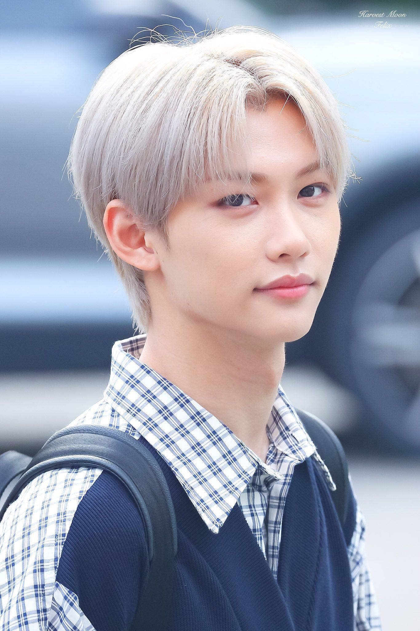 Stray Kids 桌布 壁紙 — 一位年輕男子留著鉑金色頭髮，穿著格子襯衫和深色背心，背著黑色背包在戶外。