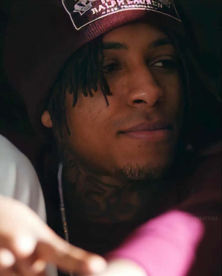 Youngboy 桌布 壁紙 — 一位年輕男子的近距離肖像，他有刺青，戴著栗色帽子，冷靜地看著鏡頭外。