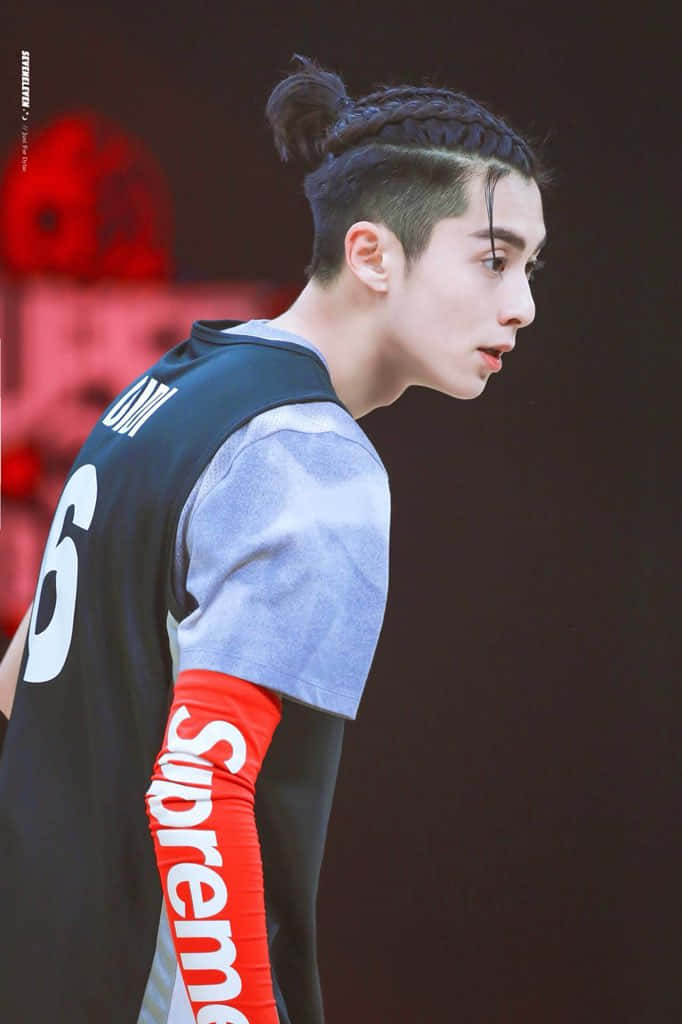 Dylan Wang 桌布 壁紙 — 一位年輕男子紮著辮子髮髻，身穿黑灰色籃球球衣，紅色Supreme袖子，背景為模糊的紅色。