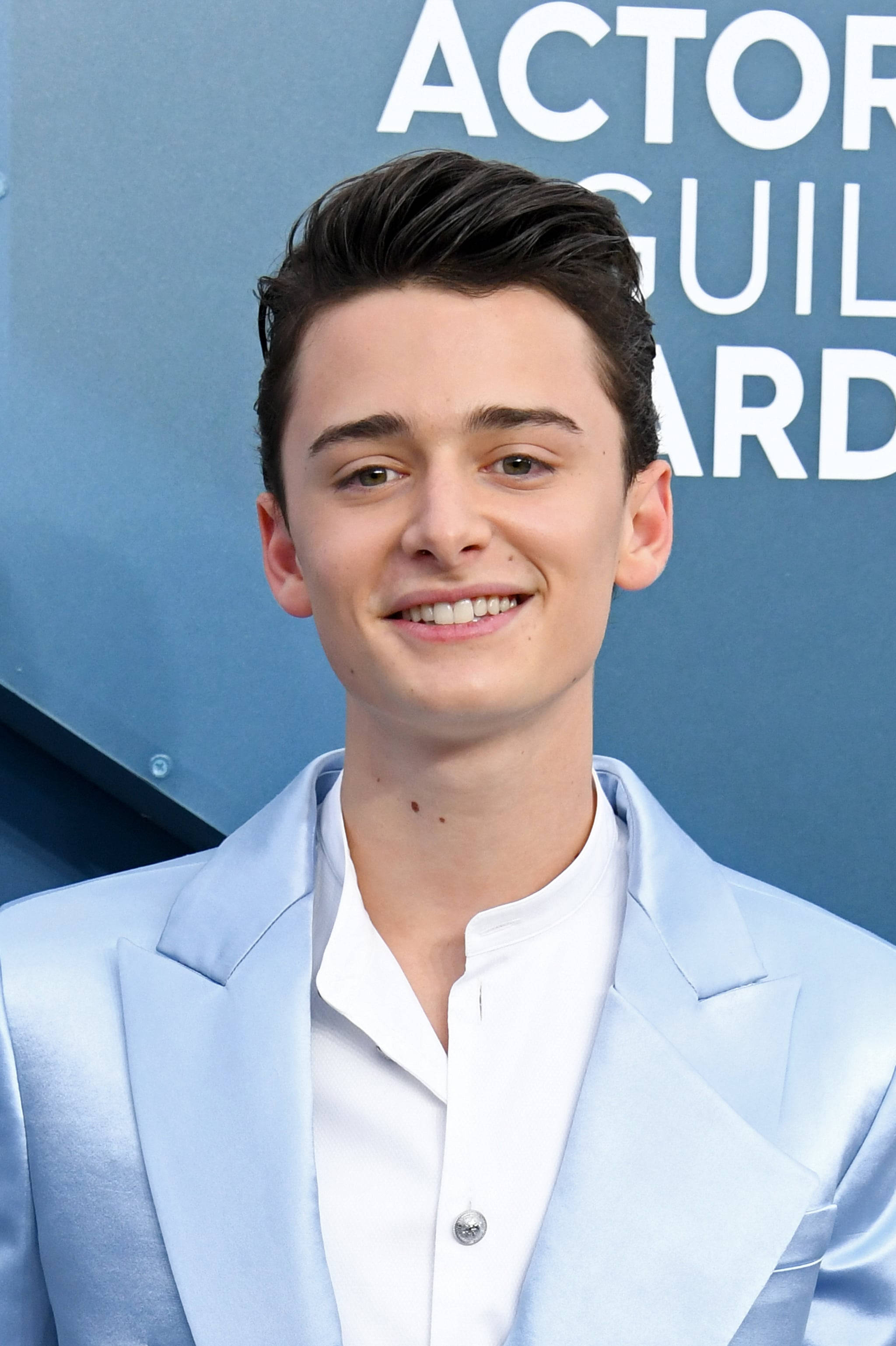 Celebrity 桌布 壁紙 — 一位年輕男子身穿淺藍色西裝，在藍色「Actor Guild Awards」背景前對著鏡頭燦爛微笑。