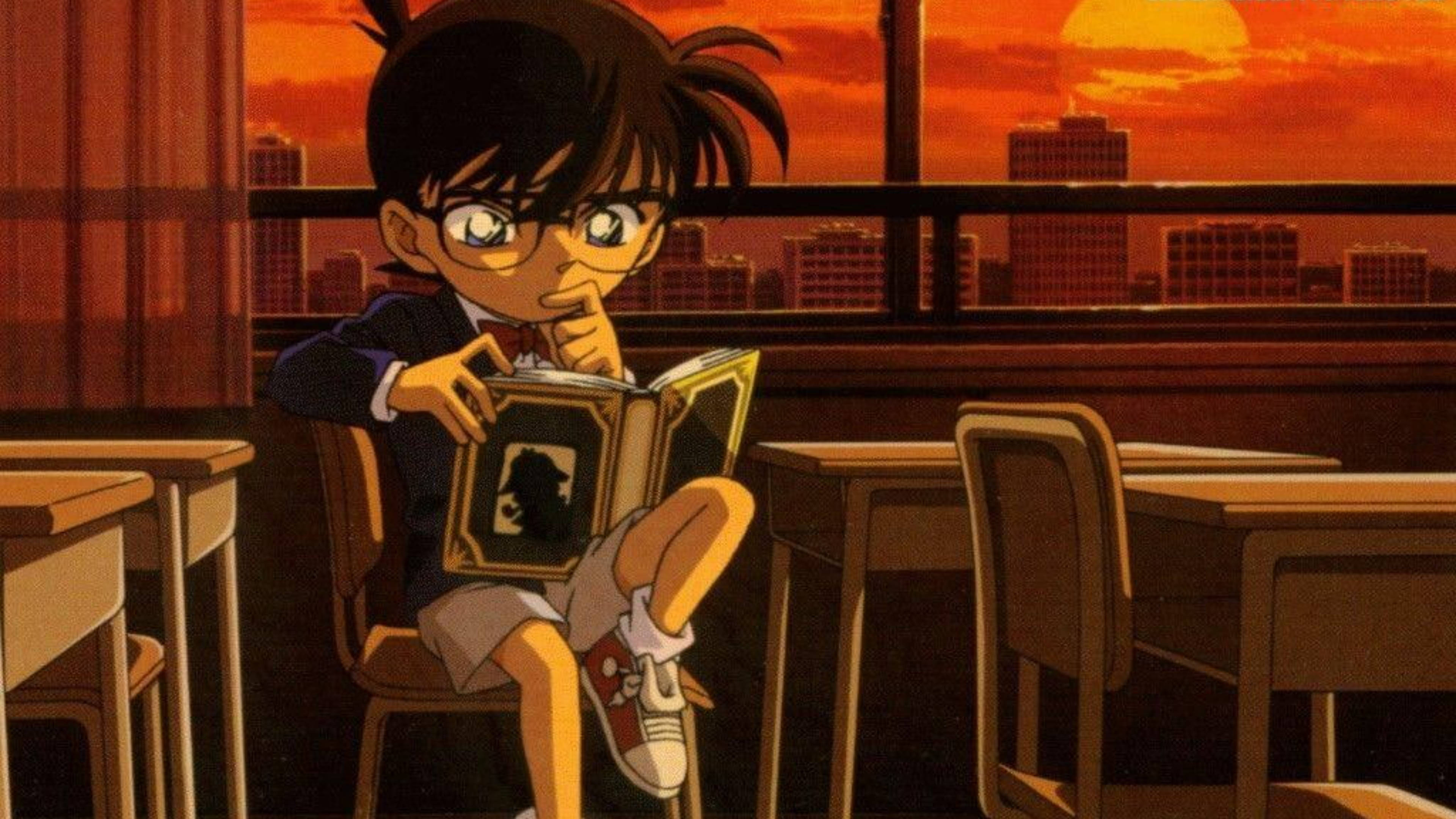 conan 桌布 壁紙 — 一位年輕的動漫偵探盤腿坐在教室的椅子上，閱讀一本懸疑小說，身後燃燒般的夕陽閃耀著光芒。