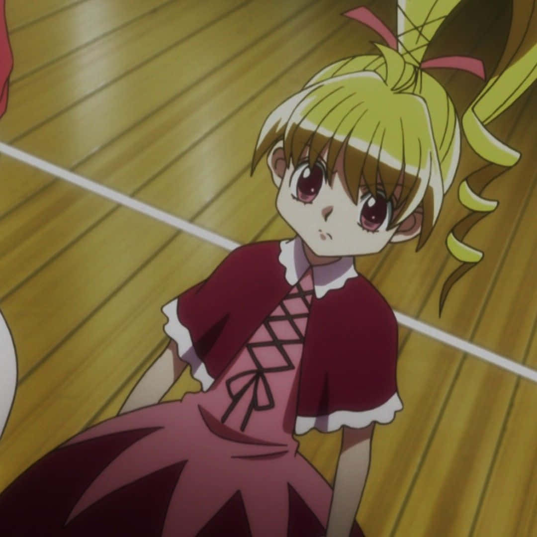 Hunter X Hunter Bisky 桌布 壁紙 — 一位年輕的動漫女孩，金髮紅眼，穿著帶有白色蕾絲邊的栗色連衣裙，坐在木地板上。