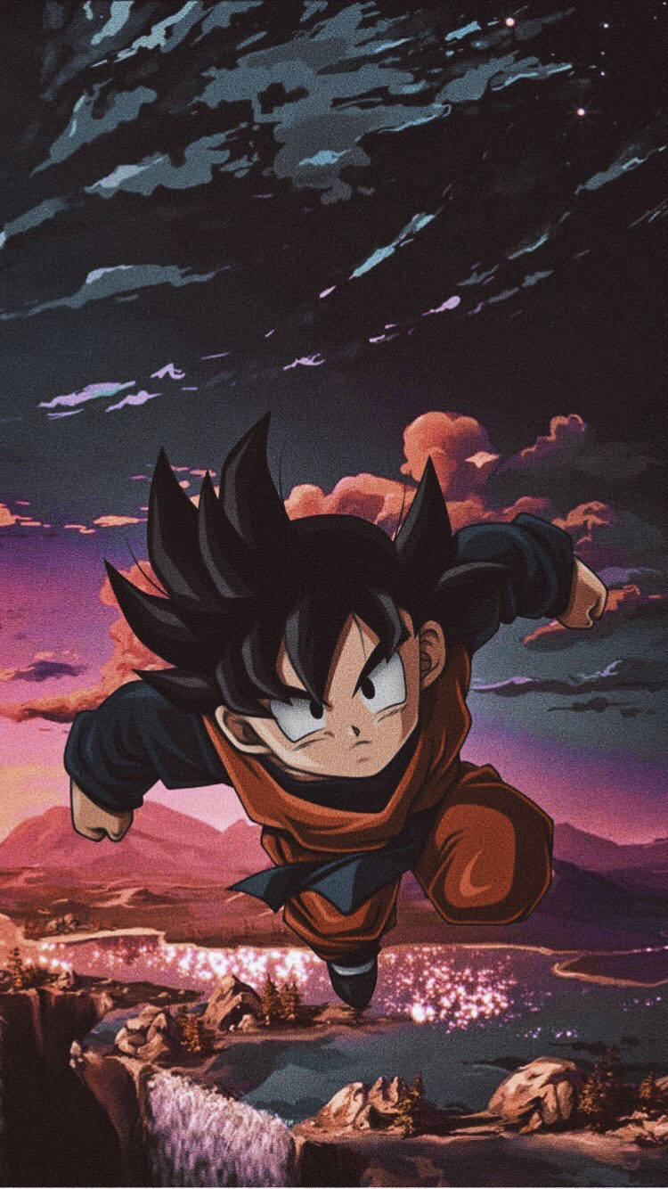 Goten 桌布 壁紙 — 一位年輕的動漫戰士在暮色天空中翱翔，下方是發光的山谷，有崎嶇的懸崖和遠山。