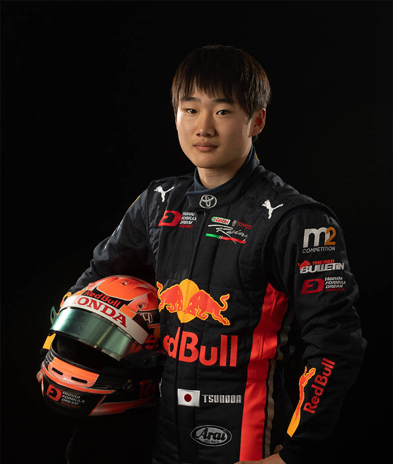 紅牛 桌布 壁紙 — 一位年輕的日本賽車手穿著Red Bull Honda賽車服，在黑色背景前拿著頭盔。