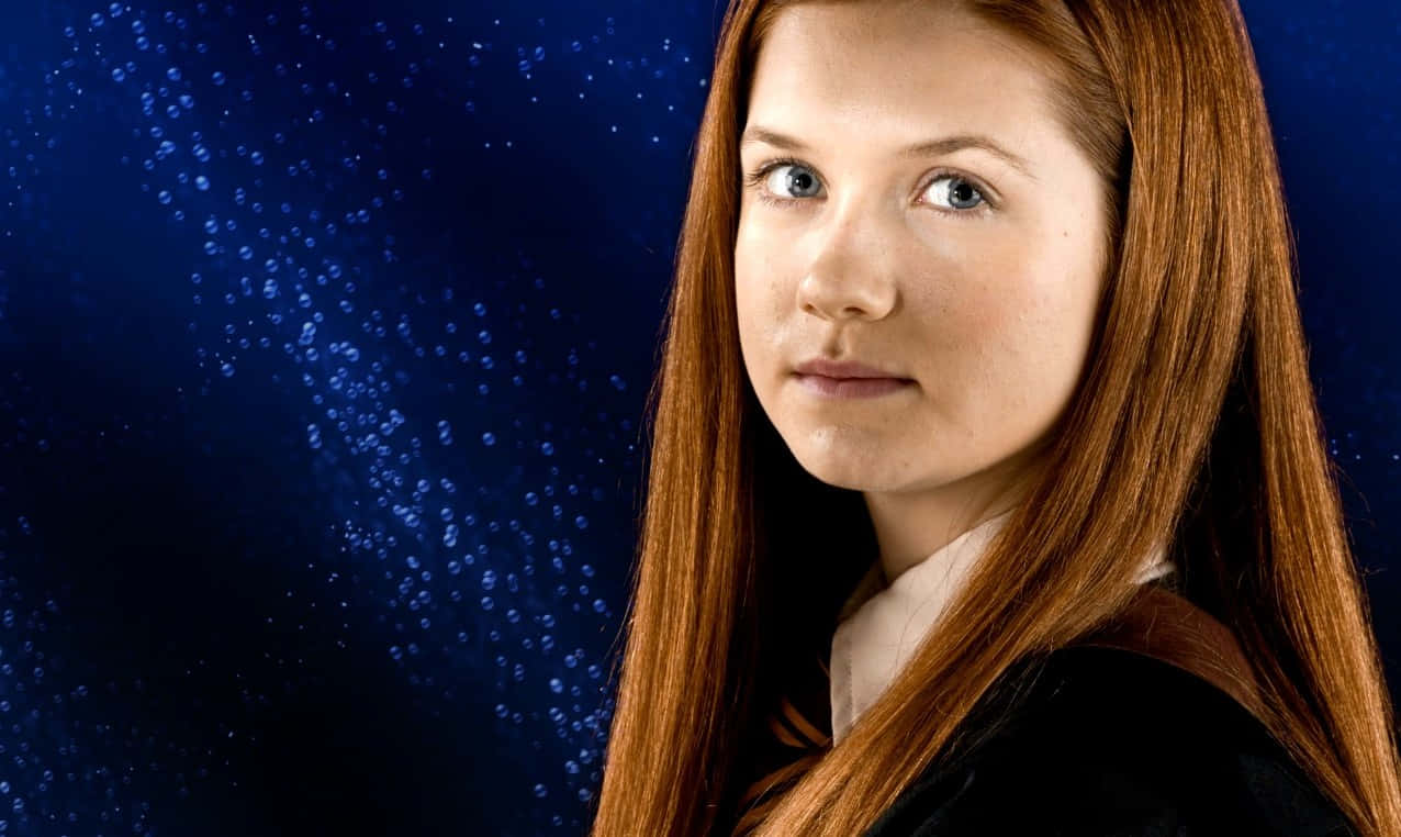 Ginny Weasley 桌布 壁紙 — 一位年輕的紅髮女子在深藍色星空背景下平靜地凝視。
