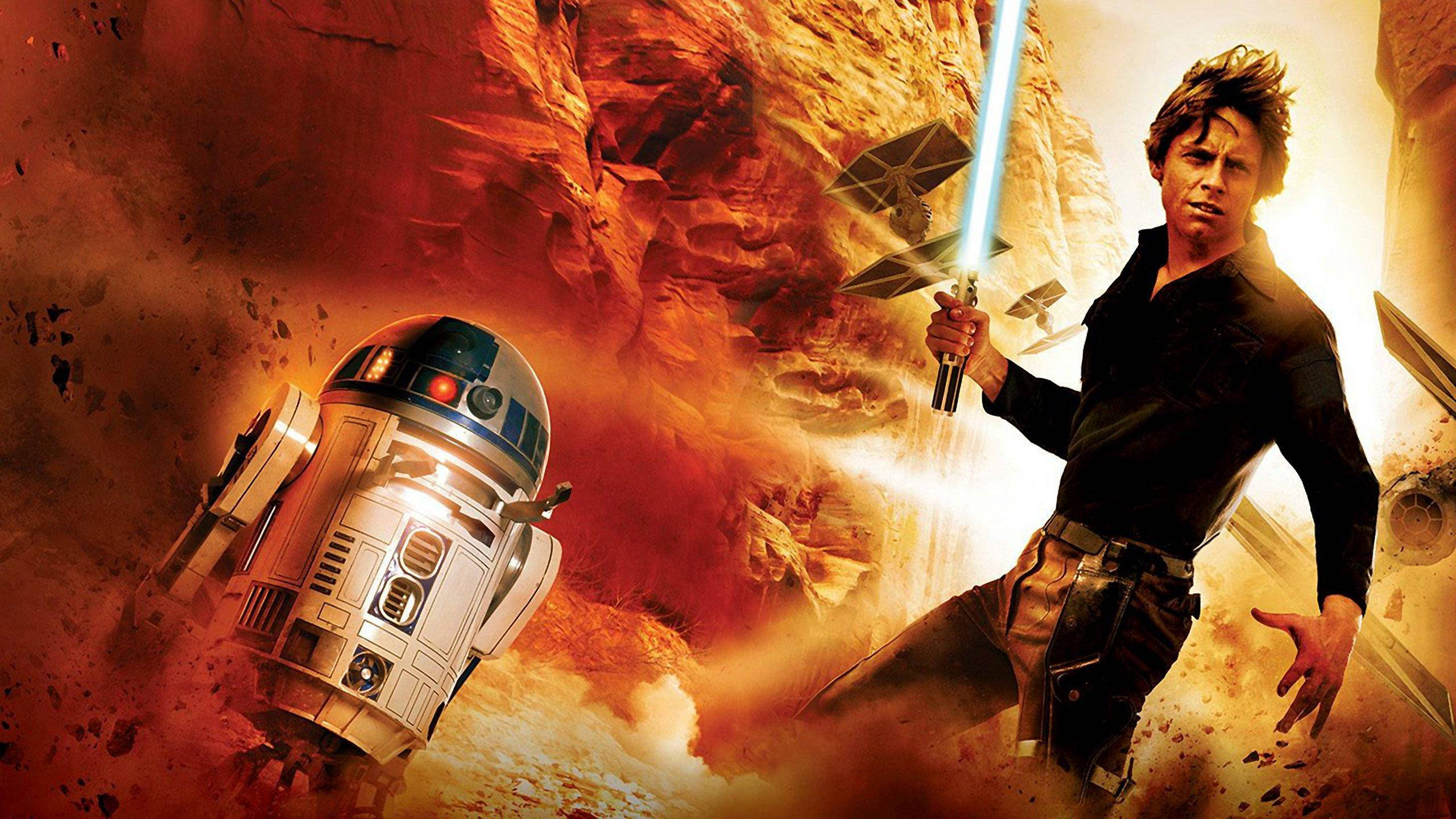 Star Wars Luke Skywalker 4K 桌布 壁紙 — 一位年輕的絕地武士手持藍色光劍，站在R2-D2旁邊，身處峽谷中火熱的爆炸和飛行的TIE戰機之間。