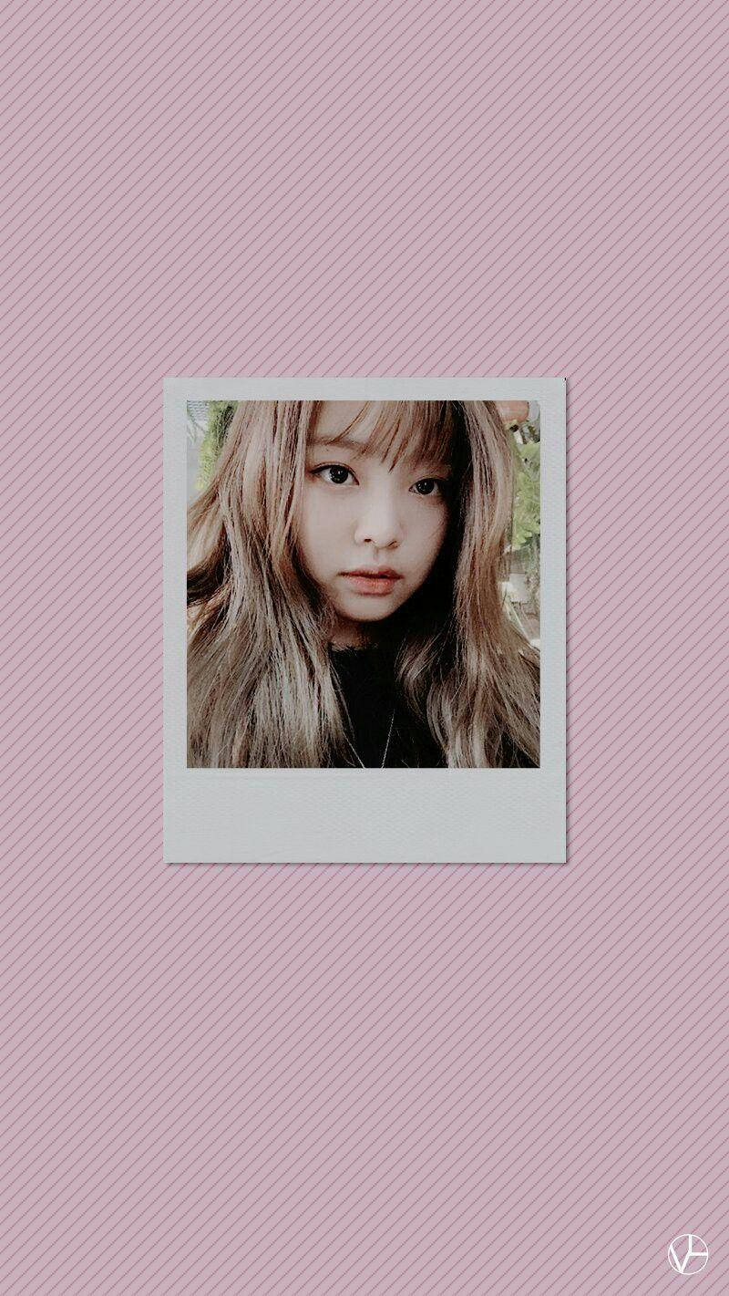 Jennie 桌布 壁紙 — 一位年輕的長髮金髮女子在粉紅色斜紋背景中央的拍立得風格照片中溫柔地凝視。