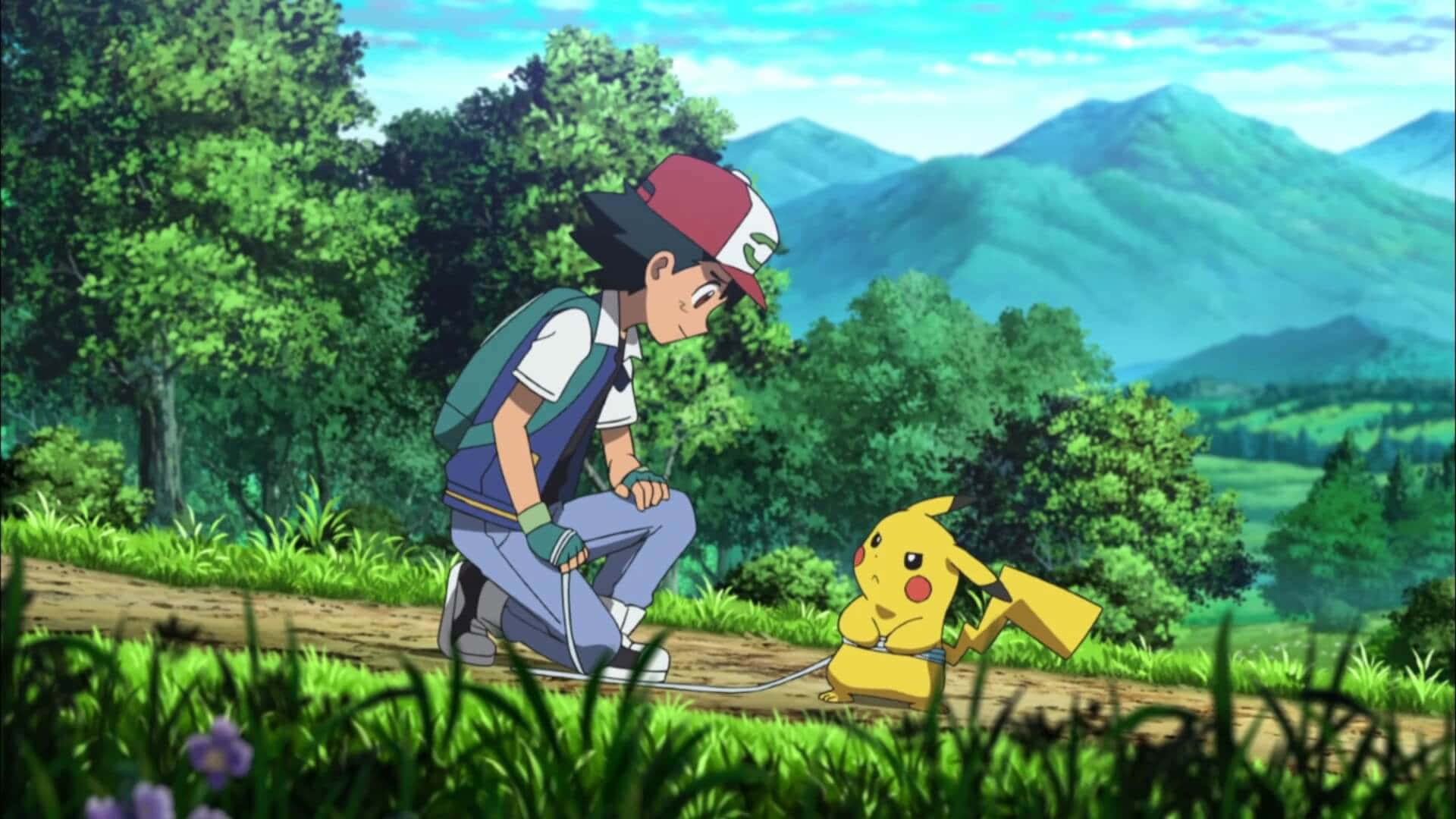 Ash And Pikachu 桌布 壁紙 — 一位年輕訓練家跪在草地小徑上，身旁是黃色電屬性寶可夢皮卡丘，背景是翠綠的山巒。
