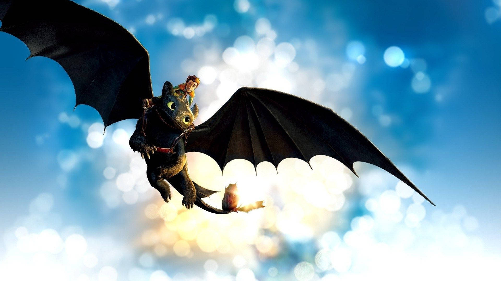 馴龍高手 桌布 壁紙 — 一位年輕騎士緊緊抓住一條黑色巨龍，在明亮的藍天中翱翔，伴隨著發光的散景燈光。