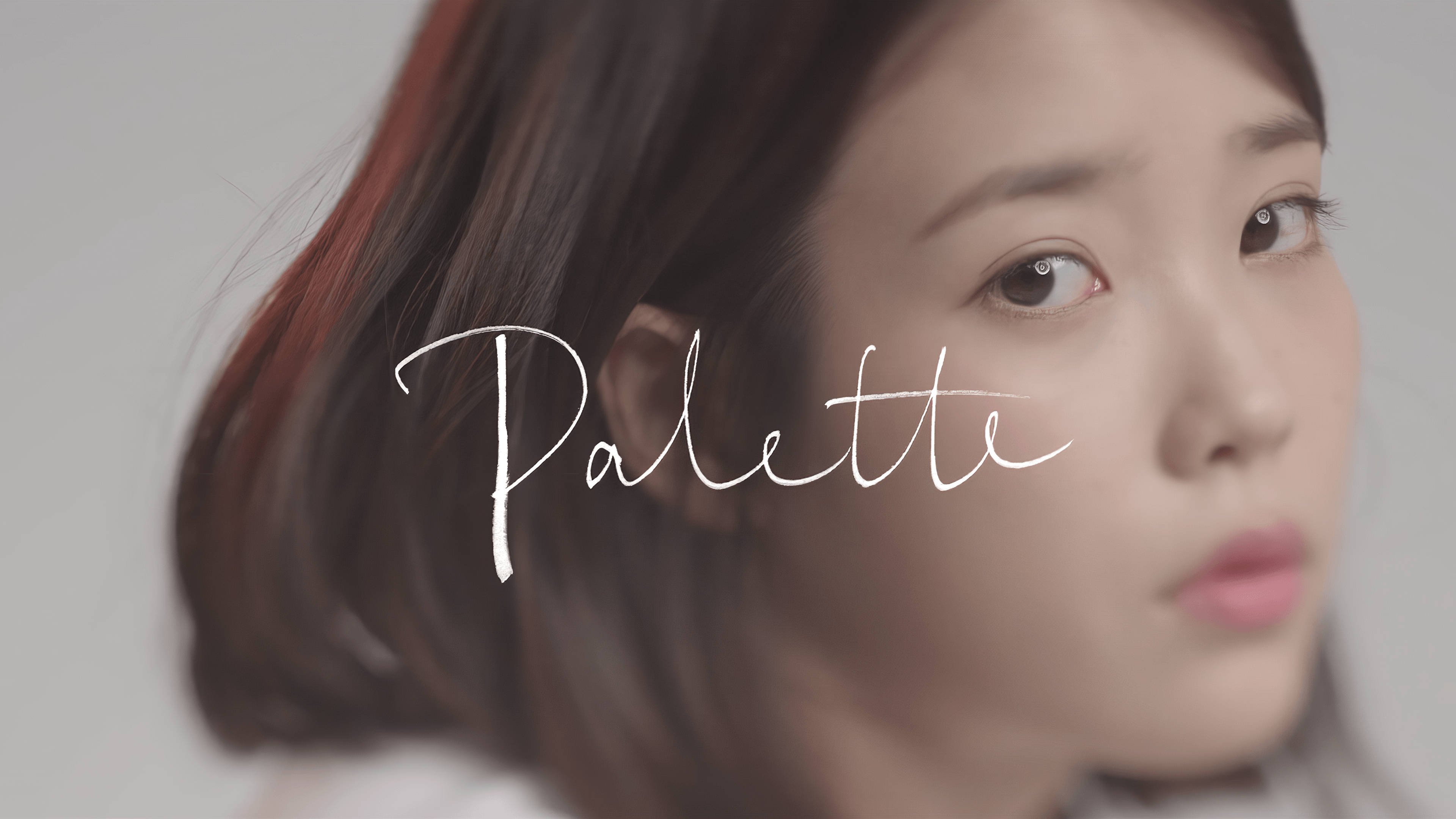 Kpop Aesthetic 桌布 壁紙 — 一位年輕黑髮女子的柔和焦點肖像，眼神溫柔，上面覆蓋著優雅白色字體的「Palette」字樣。
