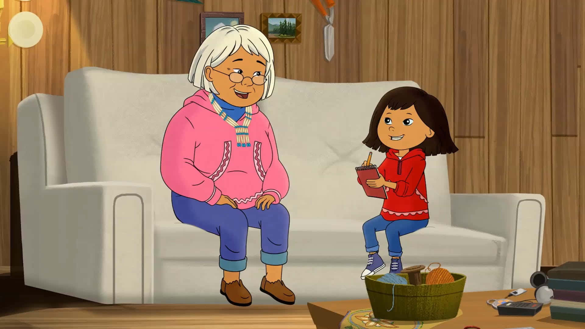 pbs kids 桌布 壁紙 — 一位年長女士和一位年輕女孩坐在舒適的木製客廳的白色沙發上，溫暖地微笑。