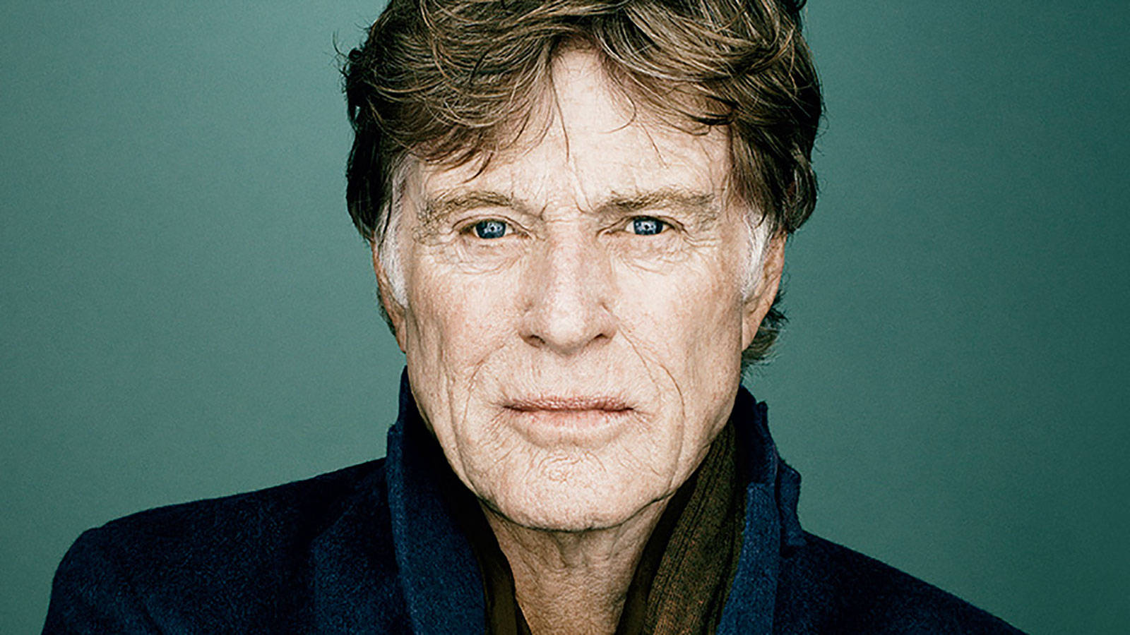 Celebrity 桌布 壁紙 — 一位年長男士的特寫肖像，擁有強烈的藍色眼睛和紋理皮膚，背景為柔和的青綠色。