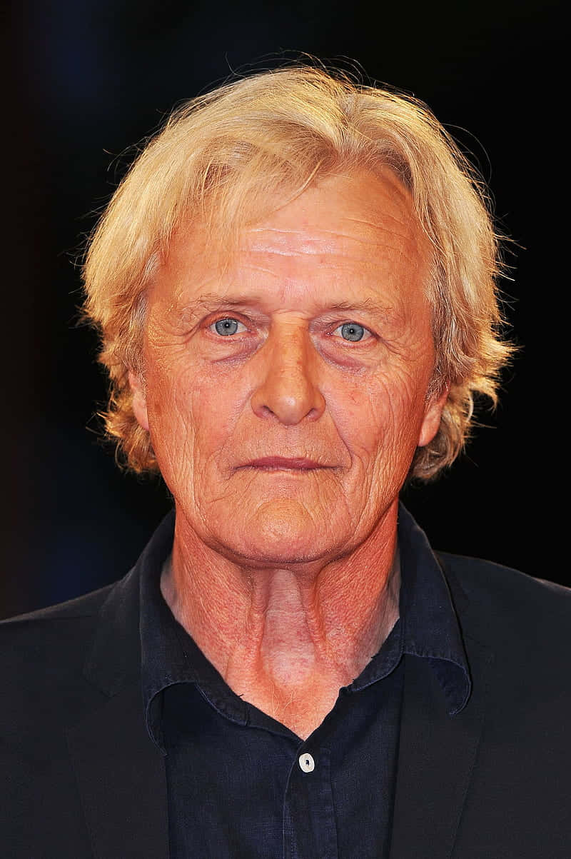 actor 桌布 壁紙 — 一位年長男士的特寫肖像，金髮碧眼，穿著深色襯衫，背景為黑色。