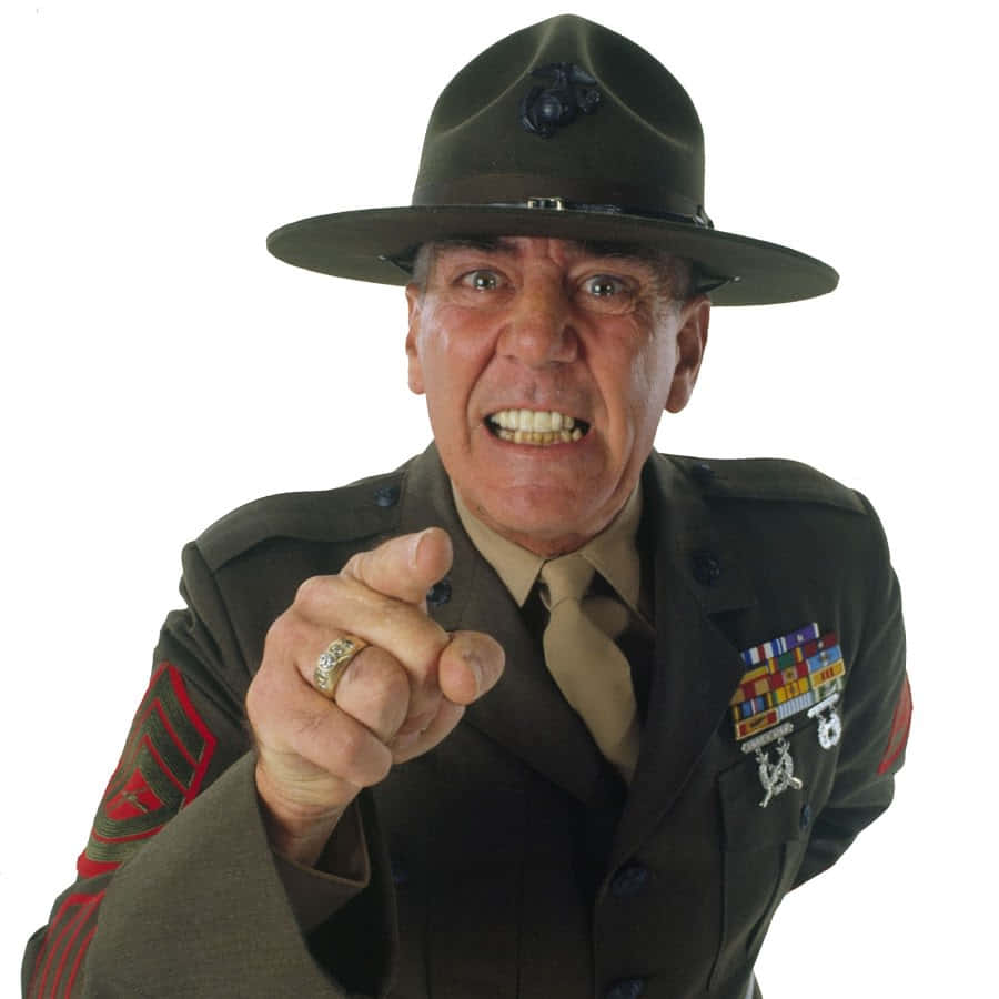 R. Lee Ermey 桌布 壁紙 — 一位年長的海軍陸戰隊軍士身穿制服，在白色背景前以強烈的表情直接指向觀眾。