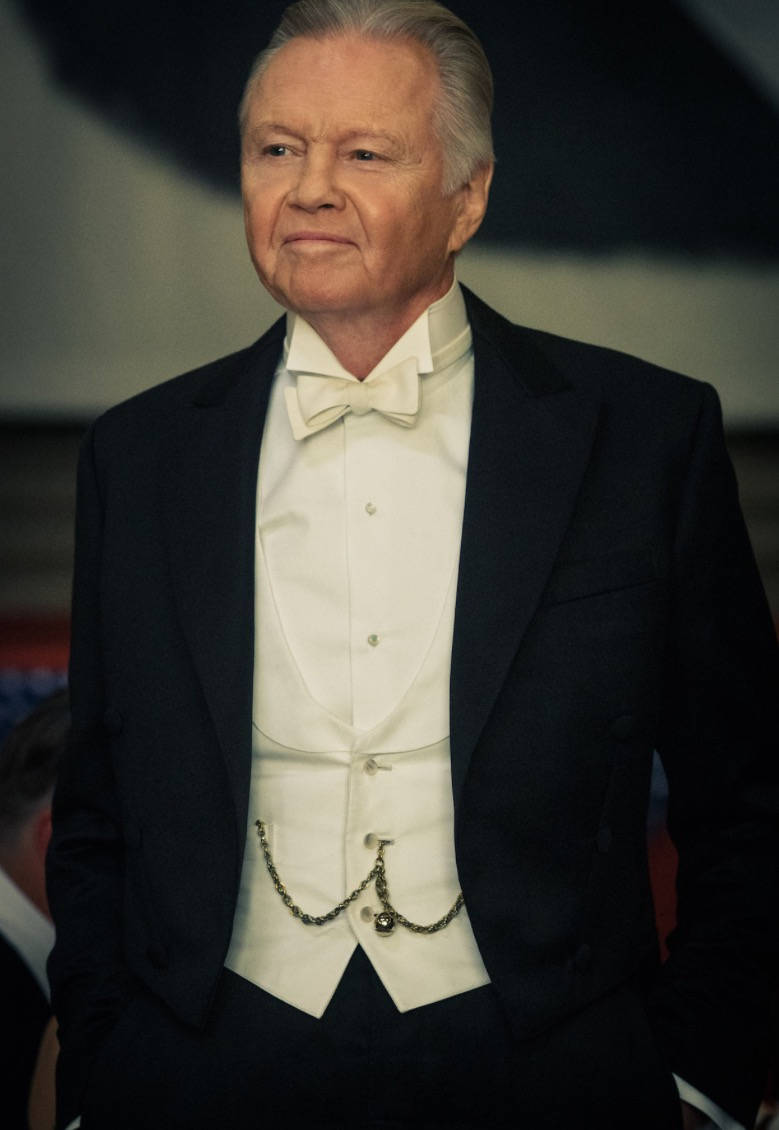 演員 桌布 壁紙 — 一位年長紳士穿著正式黑色燕尾服，搭配白色領結和背心，神情沉穩地站立。