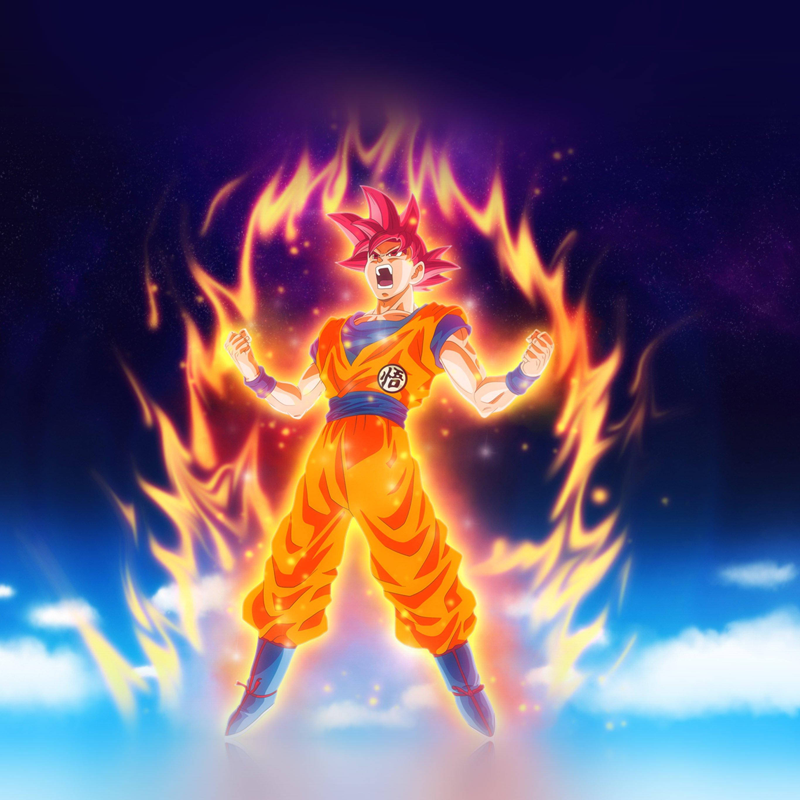 Fire Anime 桌布 壁紙 — 一位強大的動漫戰士，擁有尖刺的紅髮和橙色道服，站在燃燒的金色火焰中，背景是星空夜空和下方的雲層。