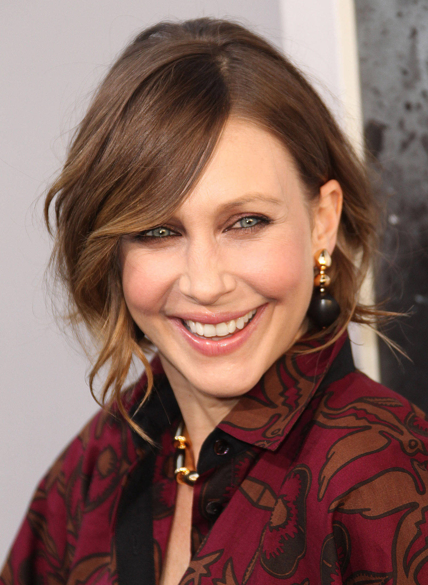 Celebrity 桌布 壁紙 — 一位微笑女士的特寫肖像，她有棕色頭髮和綠色眼睛，穿著圖案栗色襯衫和金色耳環。