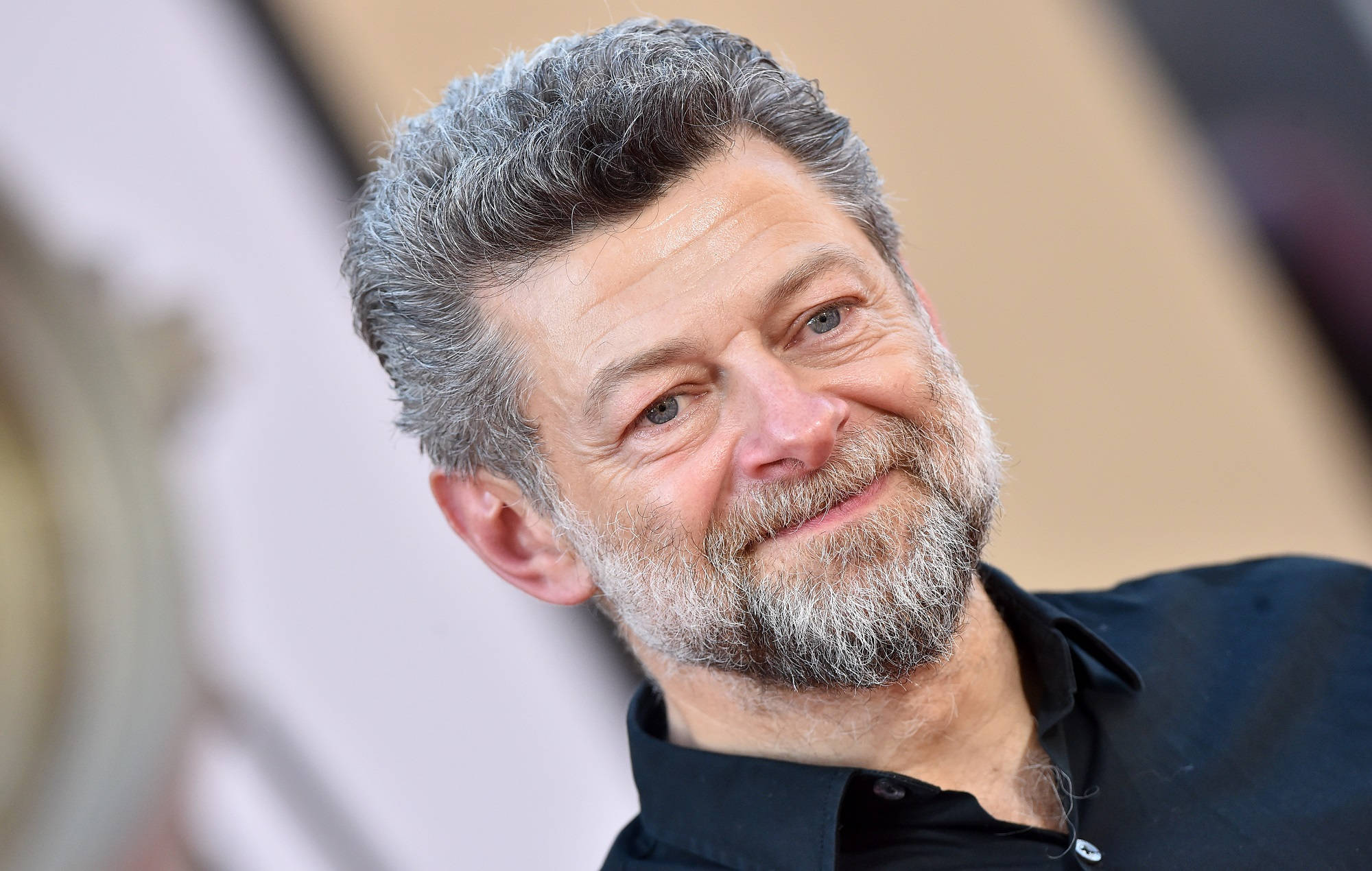 actor 桌布 壁紙 — 一位微笑男士的特寫肖像，灰白頭髮和鬍鬚，身穿黑色襯衫。