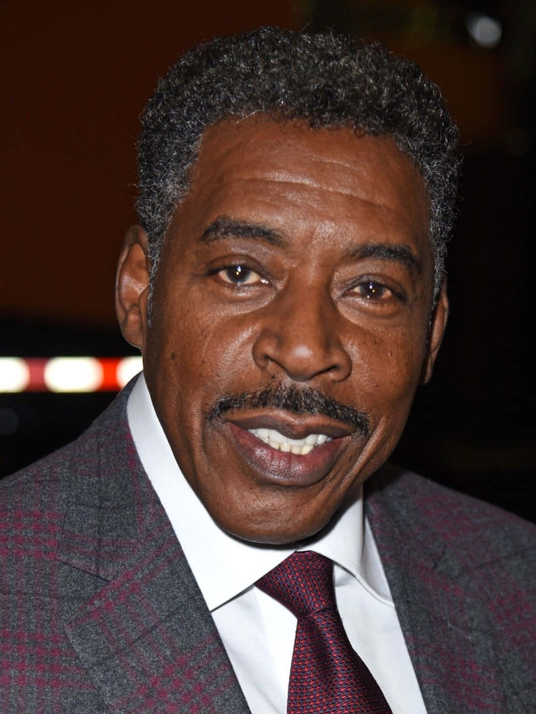 Ernie Hudson 桌布 壁紙 — 一位微笑男士的特寫肖像，頭髮花白，留鬍子，身穿圖案西裝和紅色領帶。