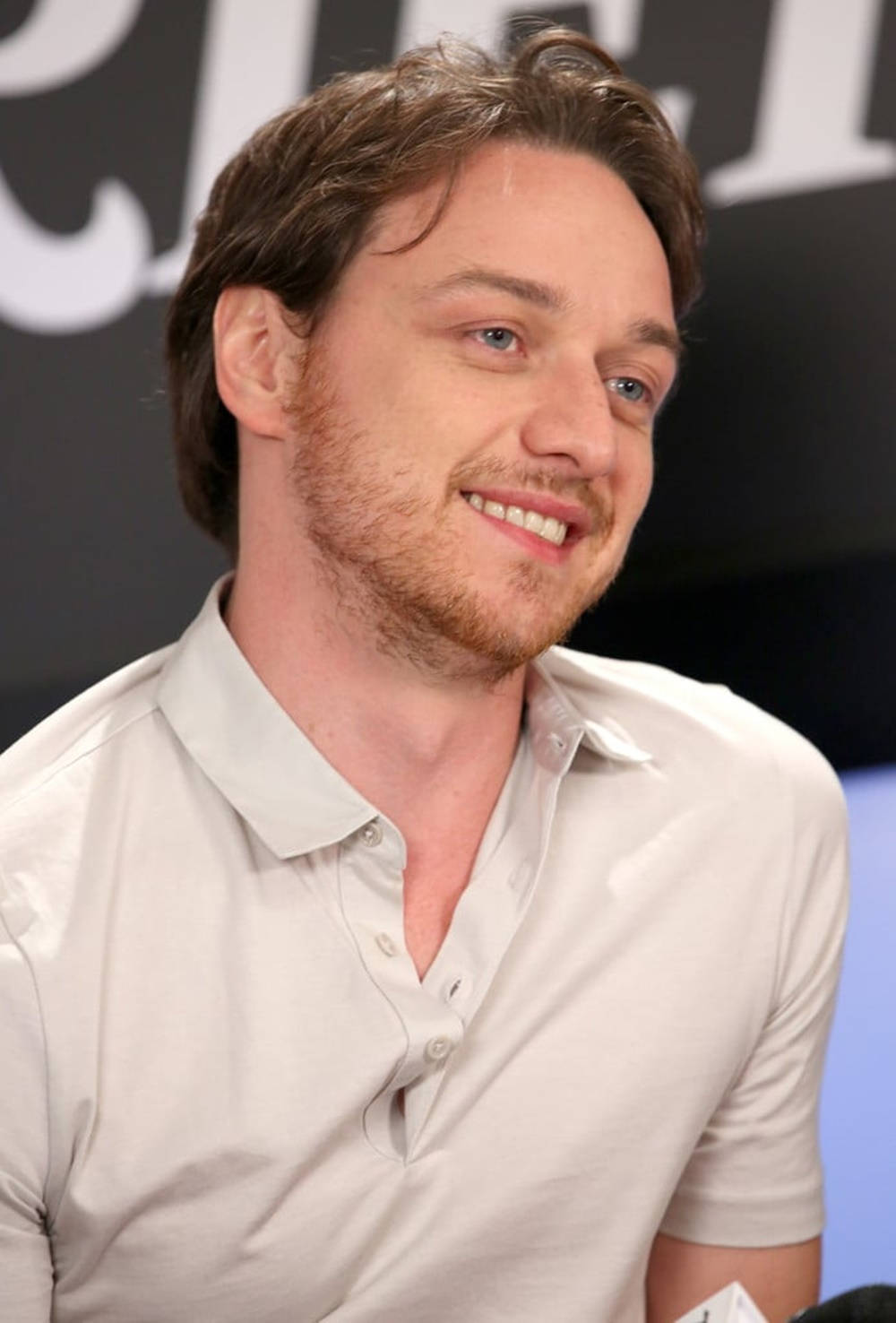 Celebrity 桌布 壁紙 — 一位微笑男士的頭像近照，棕色頭髮、藍色眼睛，身穿淺色Polo衫。