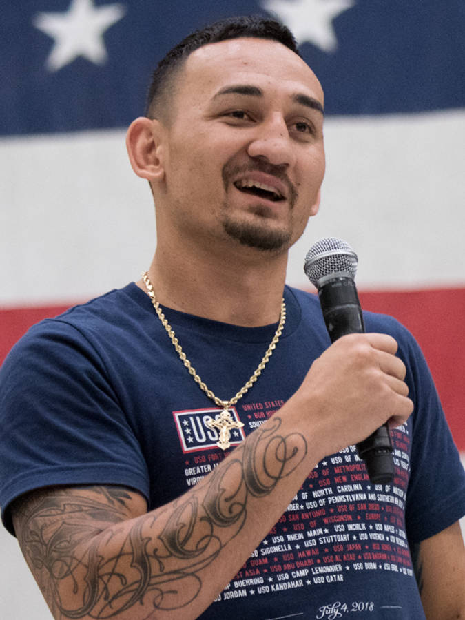 UFC 桌布 壁紙 — 一位微笑的刺青男子在美國國旗背景前拿著麥克風。