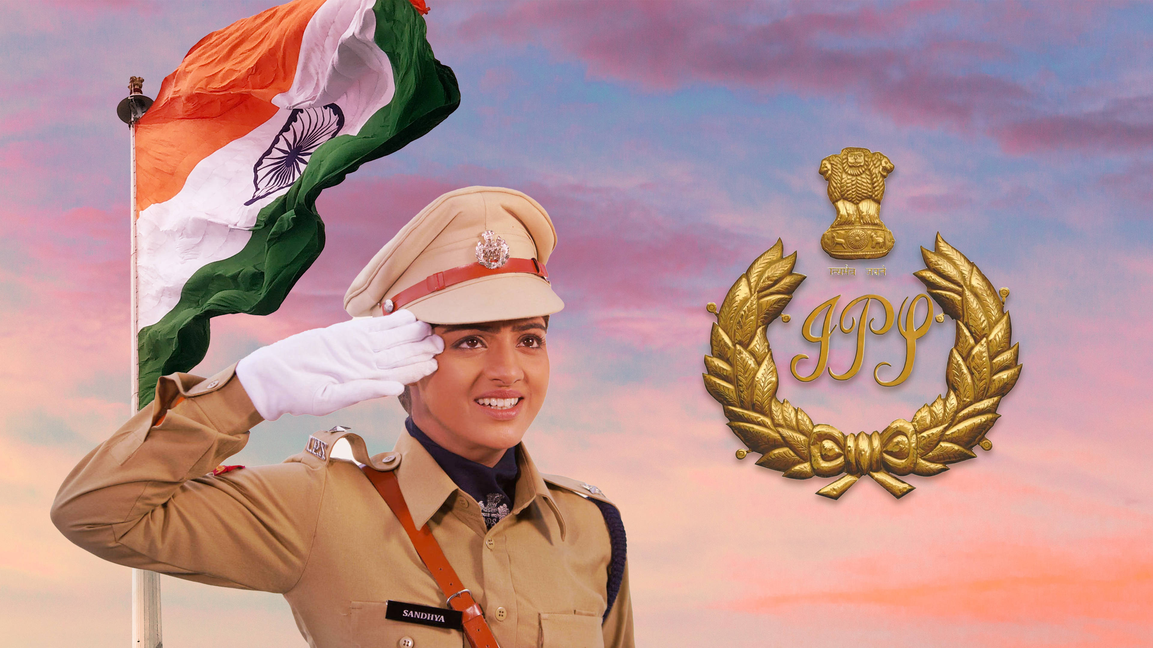 Indian Police 桌布 壁紙 — 一位微笑的印度女警驕傲地敬禮，身旁有飄揚的國旗和金色的IPS徽章，背景是柔和的粉紫色日落天空。