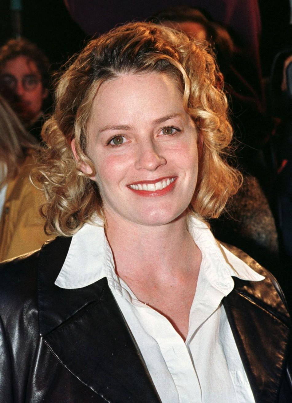 Celebrity 桌布 壁紙 — 一位微笑的女士，金色捲髮，在公共活動中穿著黑色皮夾克，內搭白色有領襯衫。