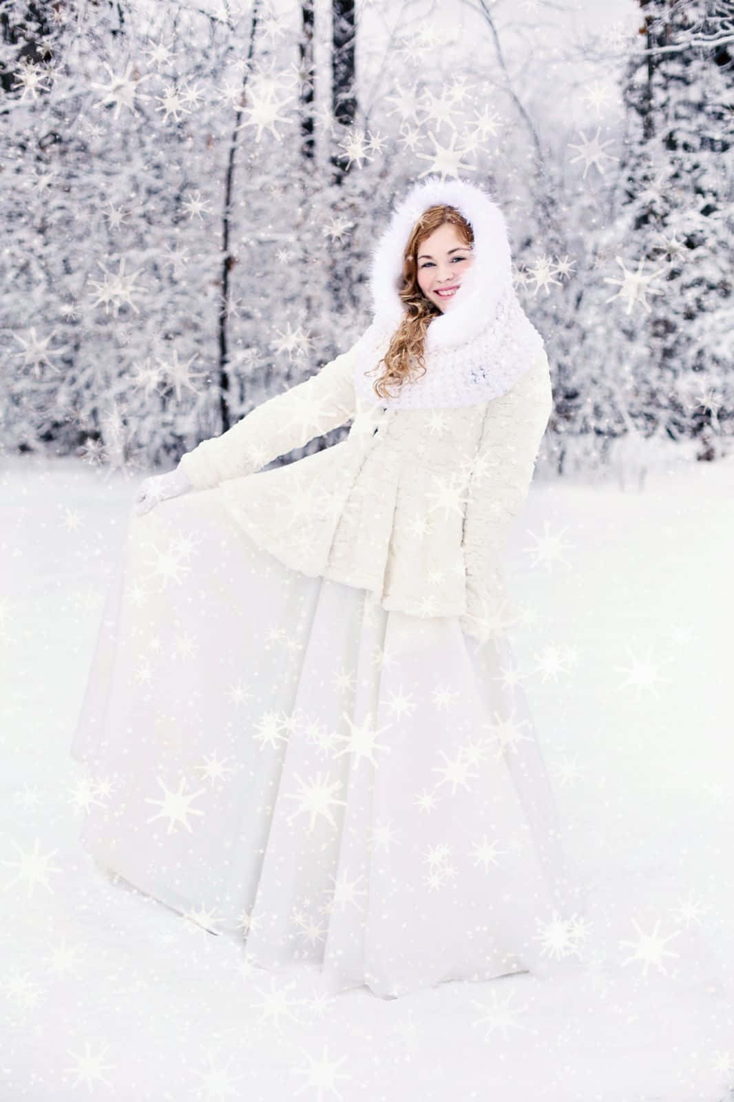 Winter Fashion 桌布 壁紙 — 一位微笑的女子穿著白色冬季外套站在雪地森林中，發光的雪花在她周圍旋轉。