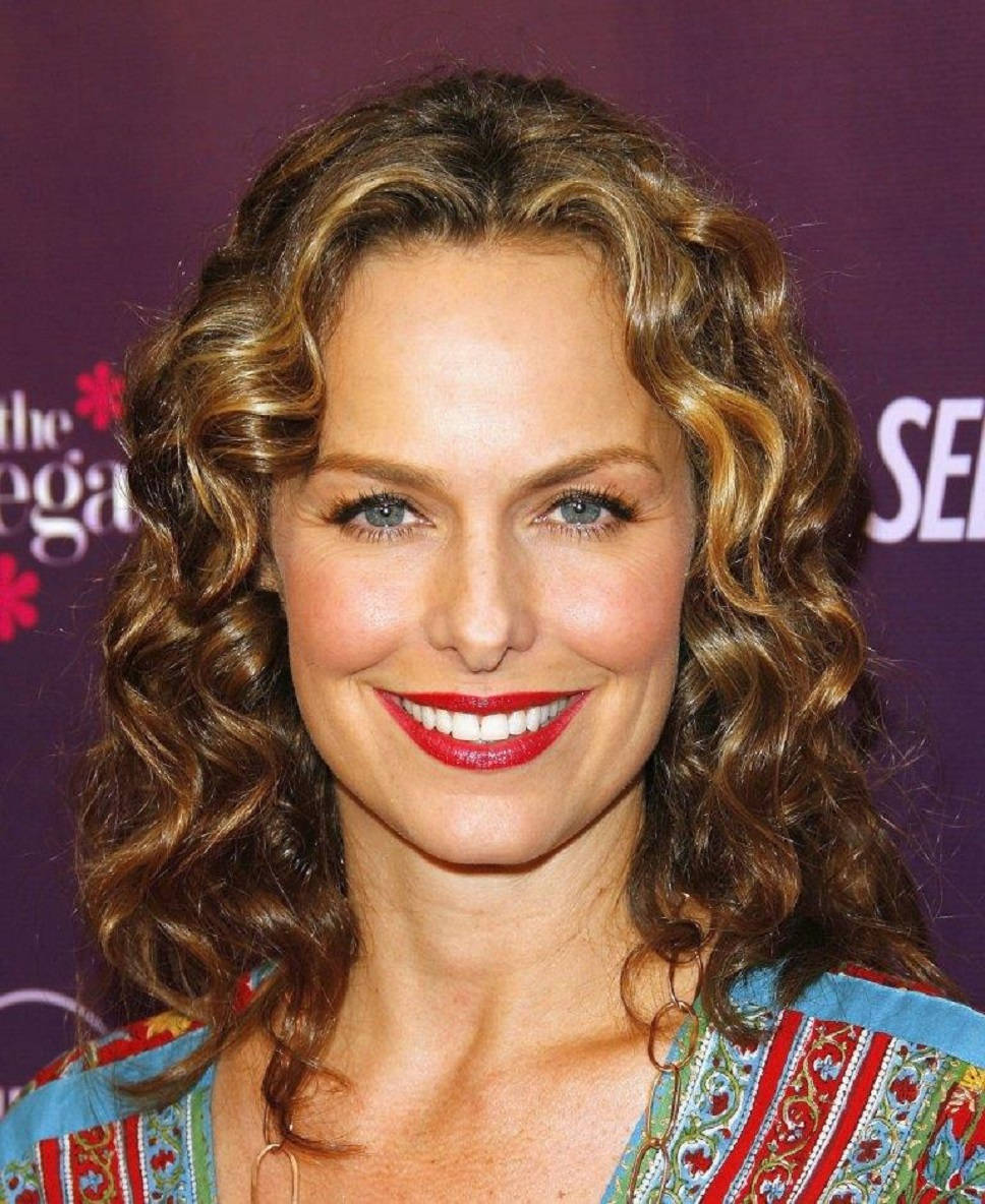 Celebrity 桌布 壁紙 — 一位微笑的女性，擁有豐盈的棕色捲髮和大膽的紅色唇膏，在紫色活動背景前擺姿勢。