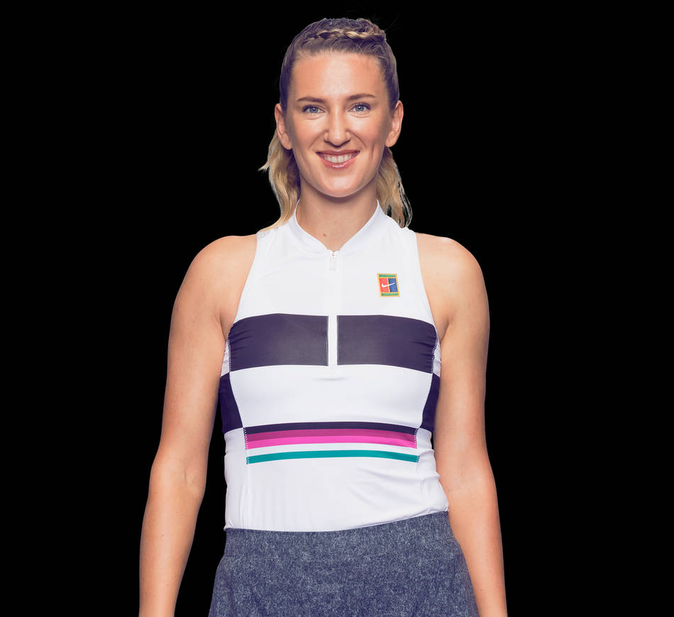 Athletic 桌布 壁紙 — 一位微笑的女性身穿白色自行車服，帶有鮮豔的紫色、粉紅色和藍綠色條紋，自信地站在黑色背景前。