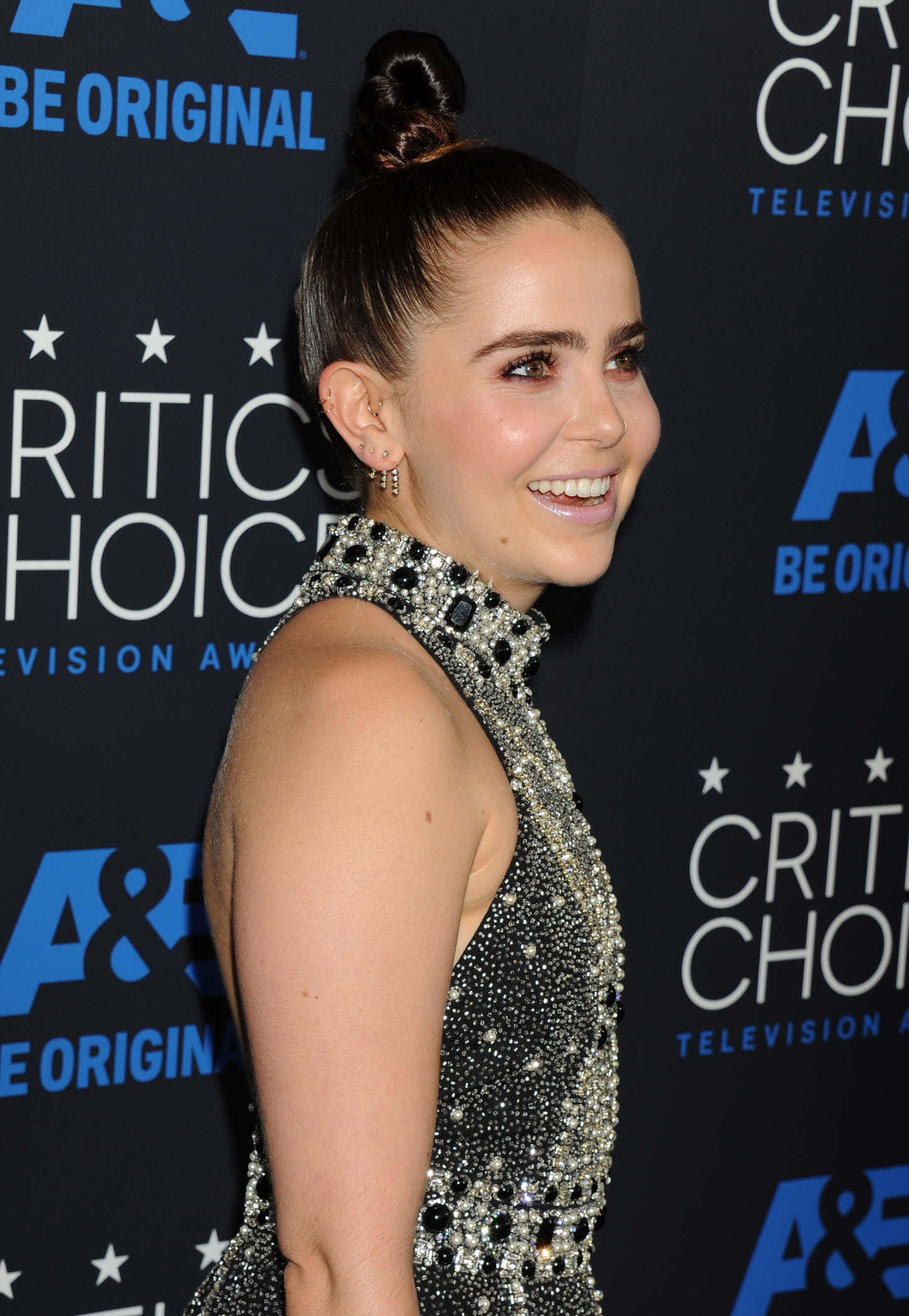 Mae Whitman 桌布 壁紙 — 一位微笑的女性身穿閃亮銀色禮服，在 Critics' Choice Television Awards 上以高髻造型擺姿勢。