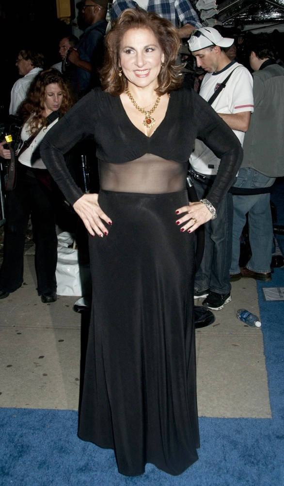 Celebrity 桌布 壁紙 — 一位微笑的女性身穿黑色露腰禮服，在擁擠活動的藍色地毯上自信地擺姿勢。