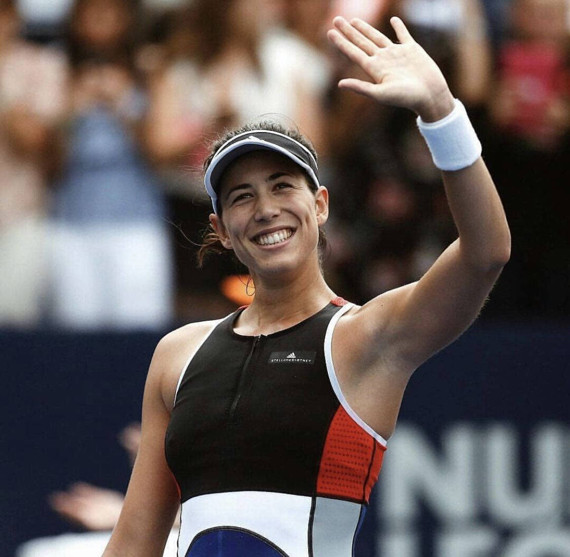Athlete 桌布 壁紙 — 一位微笑的女網球運動員穿著黑、白、紅三色運動服向球迷揮手。